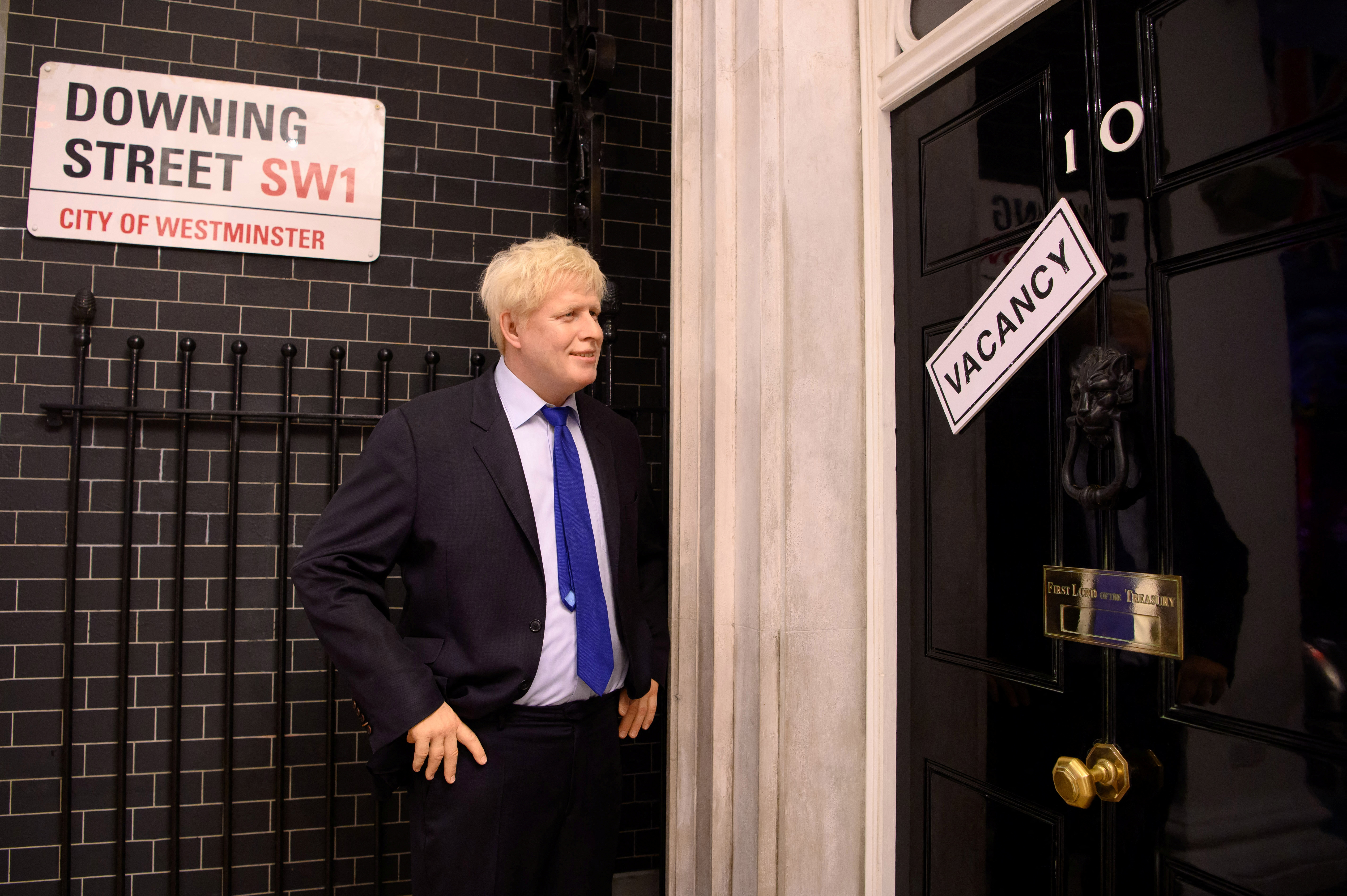 Una figura de cera de Boris Johnson se muestra junto a un cartel de "vacante" en 10 Downing Street en Madame Tussauds, en Londres (Madame Tussauds London/REUTERS)