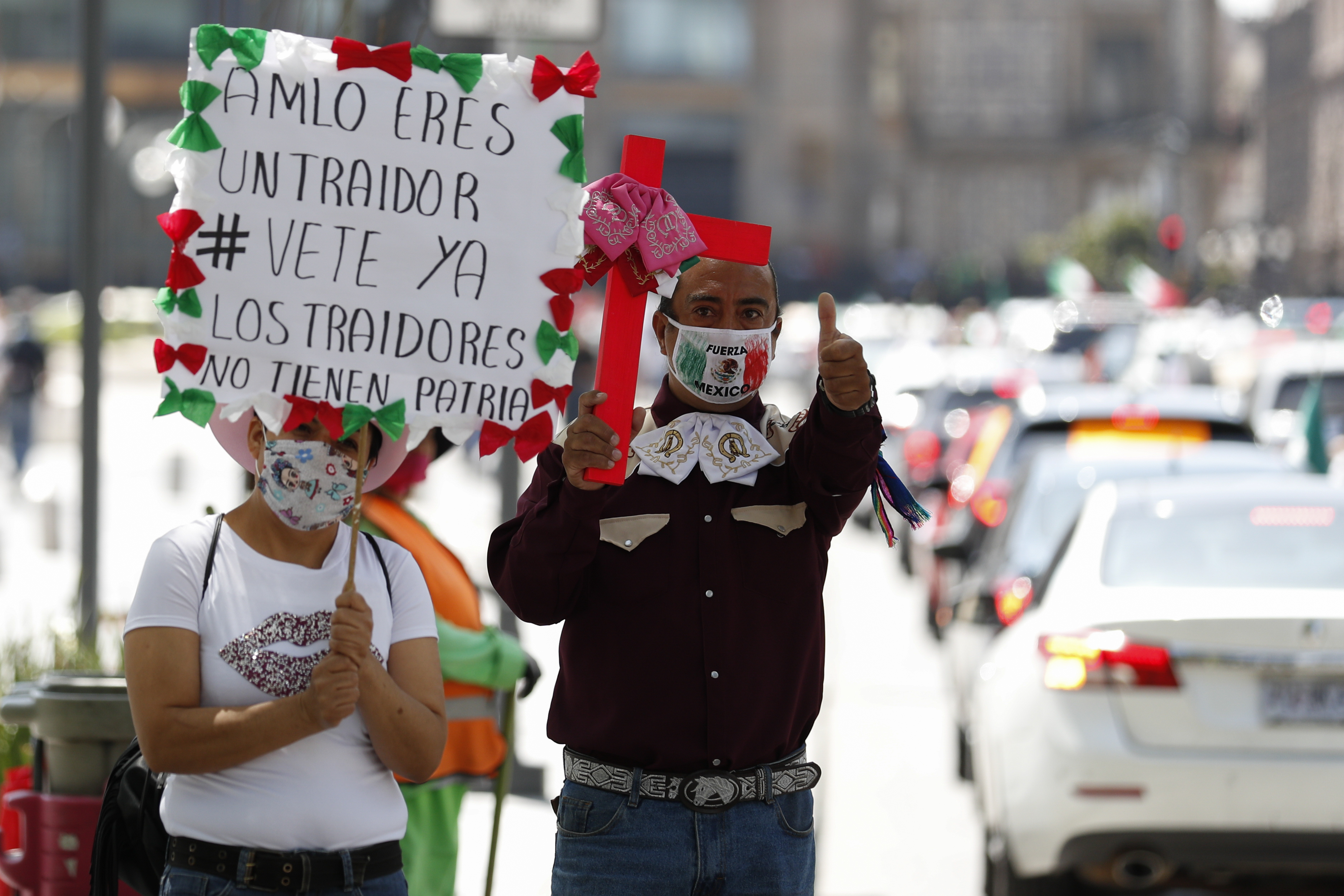 Un manifestante sostiene un letrero que dice en español