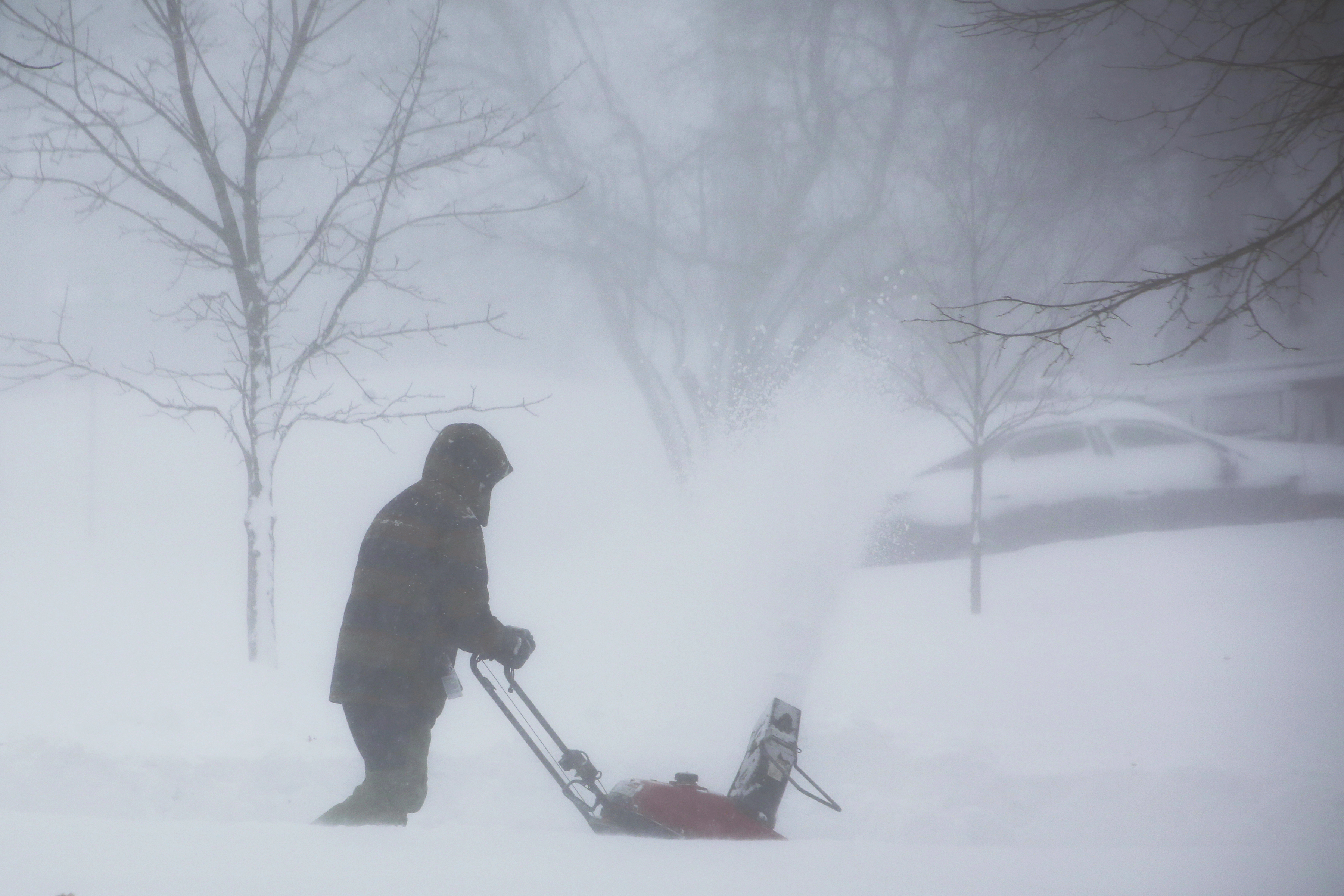Una persona limpia la nieve mientras una tormenta invernal se extiende por el oeste de Nueva York el sábado, en Amherst, N.Y. 
