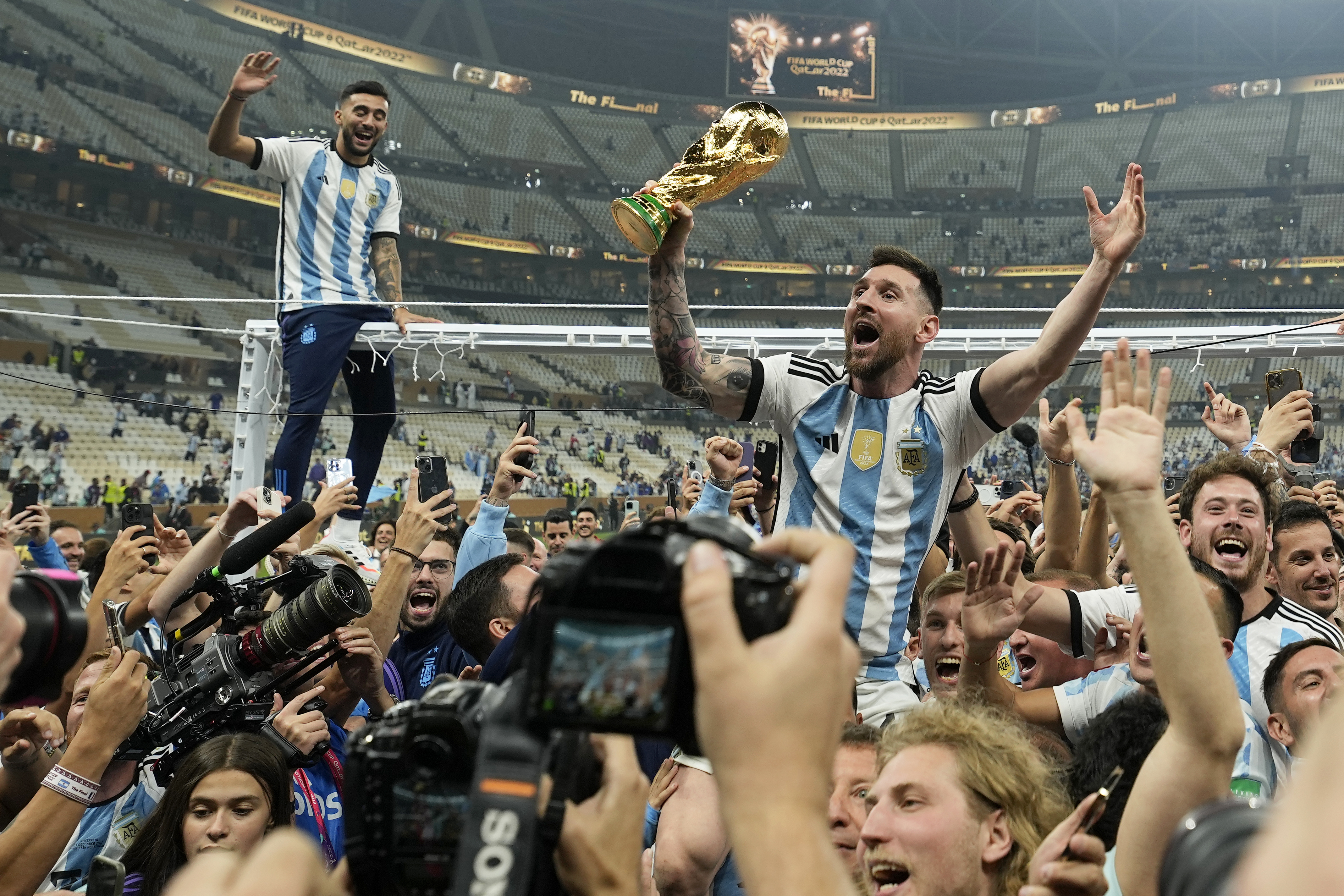 Lionel Messi celebra con el trofeo ante los hinchas tras ganar el Mundial (AP Foto/Martin Meissner)
