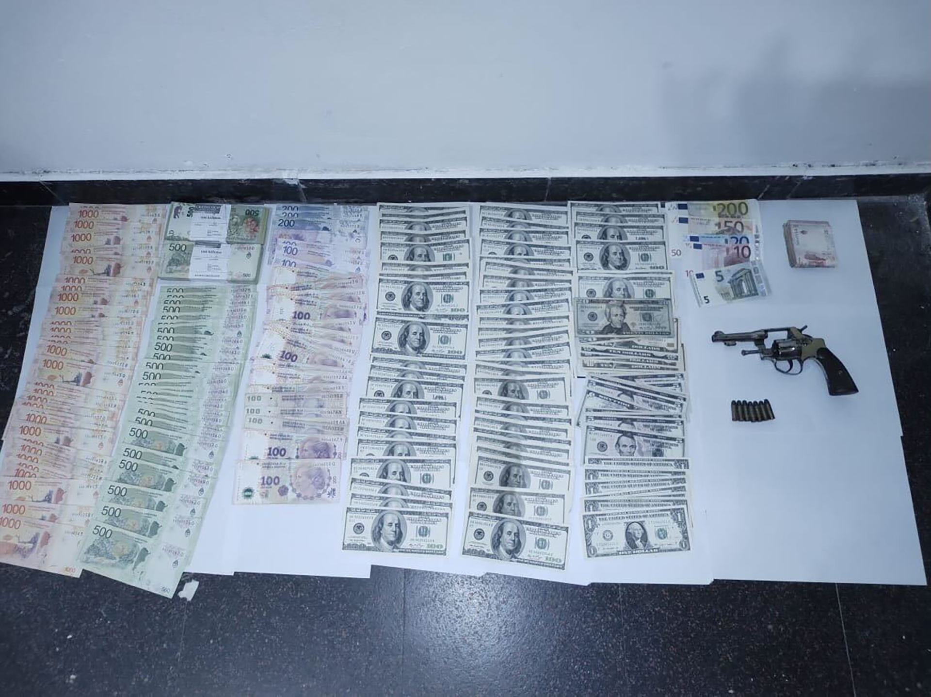El dinero y la pistola que se encontraron al momento de la detención