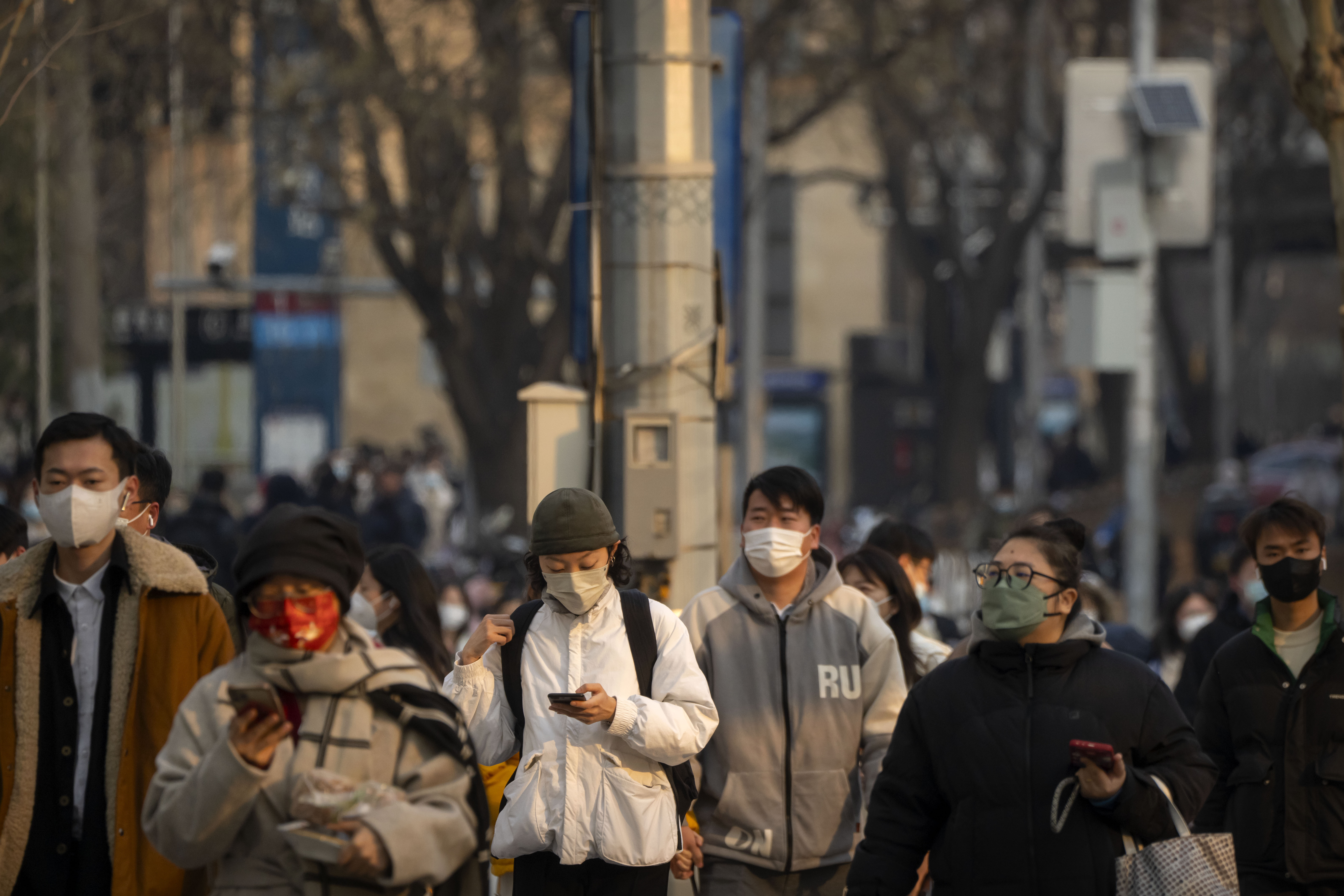 Personas con mascarillas caminan por Beijing (AP Foto/Mark Schiefelbein)