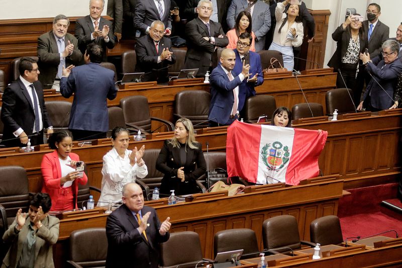 Una legisladora peruana muestra una bandera del país después de que el Congreso aprobó la destitución del presidente Pedro Castillo, en Lima, Perú. 7 de diciembre de 2022. REUTERS/Sebastián Castañeda