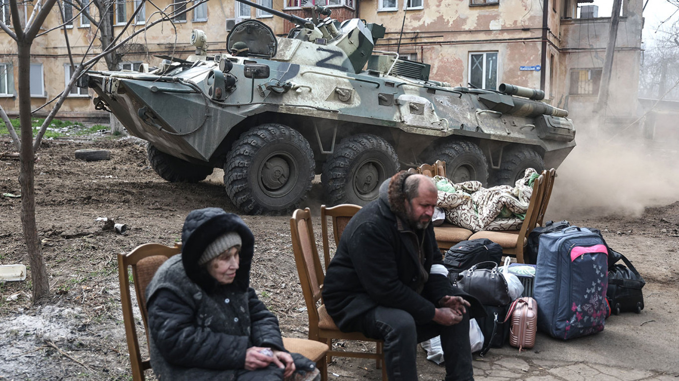 Una anciana y su hijo esperan en el medio de la destrucción de Kherson a ser traladados en forma compulsiva a territorio ruso. Luego los repartirán por algunos de los más de 60 centros de confinamiento en las zonas más remotas de Rusia. 