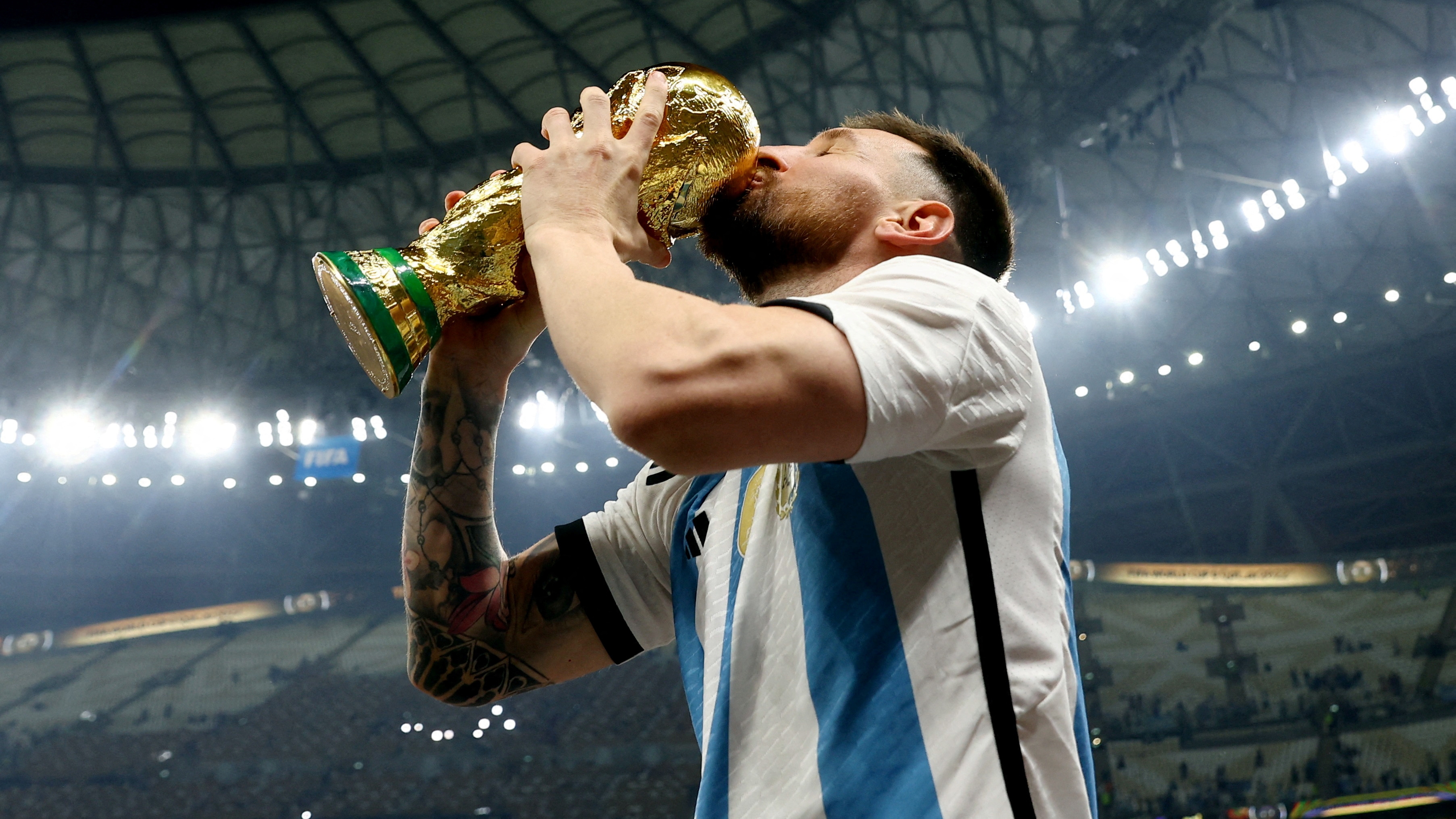 Messi besa la copa con la que dio la vuelta olímpica en el estadio Lusail. La copa que llevó una familia argentina a Qatar (REUTERS/Hannah Mckay)
