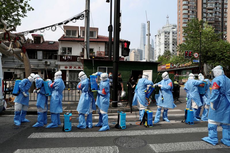 Trabajadores con trajes de protección se preparan para desinfectar un complejo residencial en el distrito de Huangpu, tras el brote de la enfermedad del coronavirus (COVID-19) en Shanghái, China, 20 de abril de 2022. REUTERS/China Daily