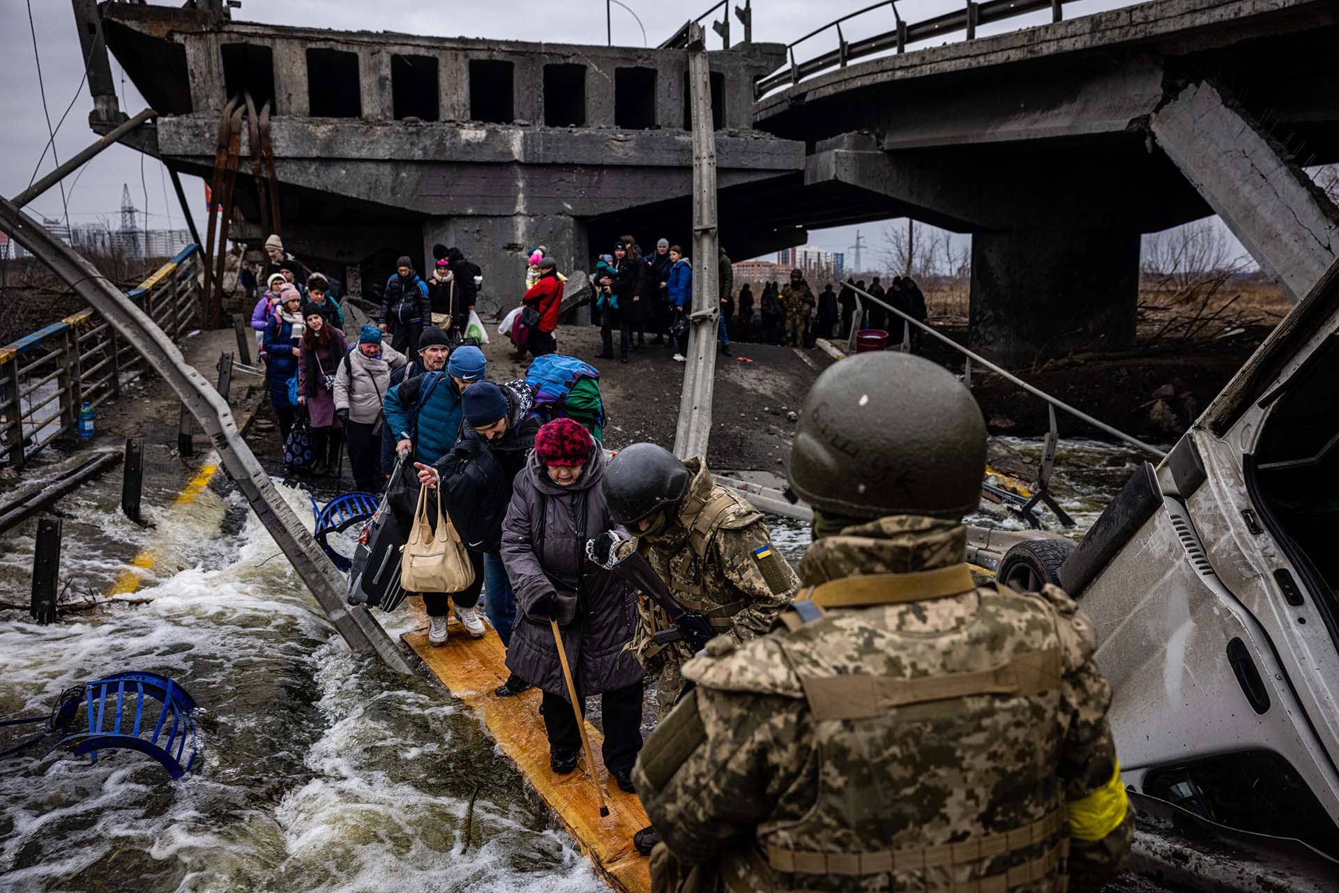 Evacuados cruzan un puente destruido mientras huyen de la ciudad de Irpin, al noroeste de Kiev, el 7 de marzo de 2022. Dimitar DILKOFF/AFP/ Archivo