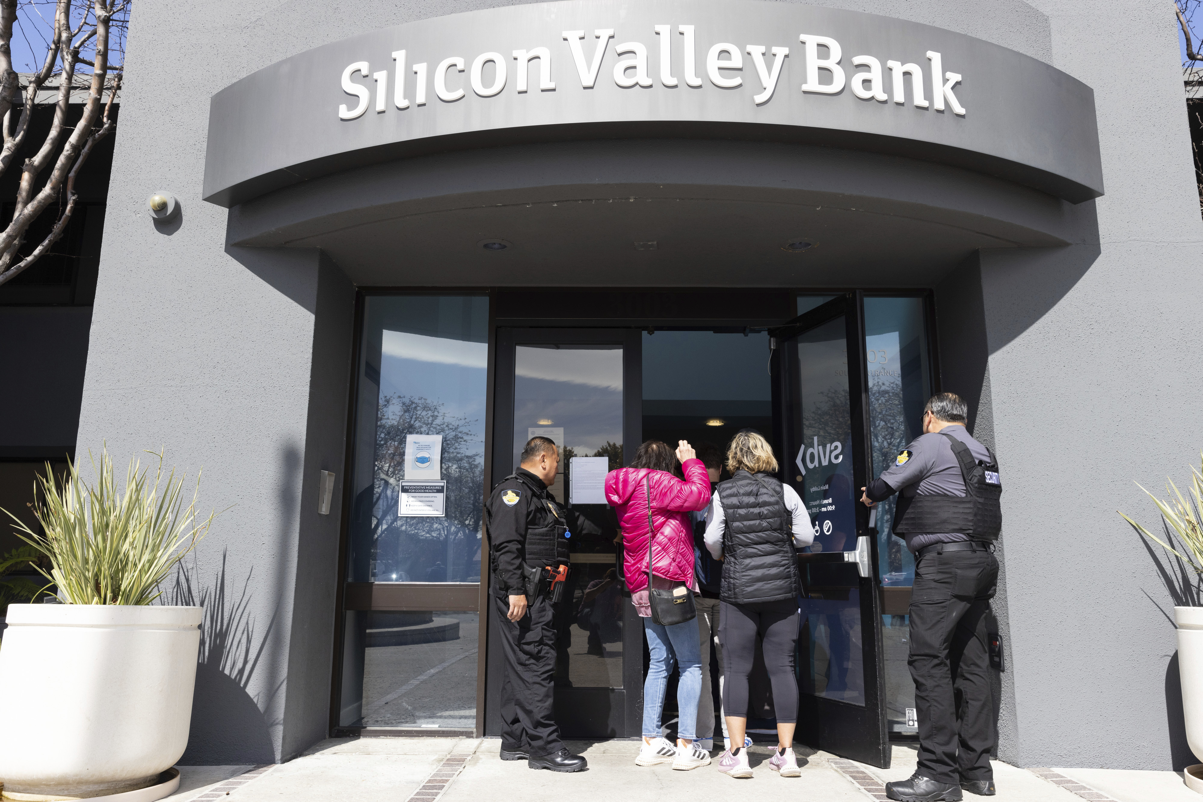 Guardias de seguridad permiten el ingreso de personas a las oficinas centrales de Silicon Valley Bank, el 13 de marzo de 2023, en Santa Clara, California. (AP Foto/ Benjamin Fanjoy, Archivo)