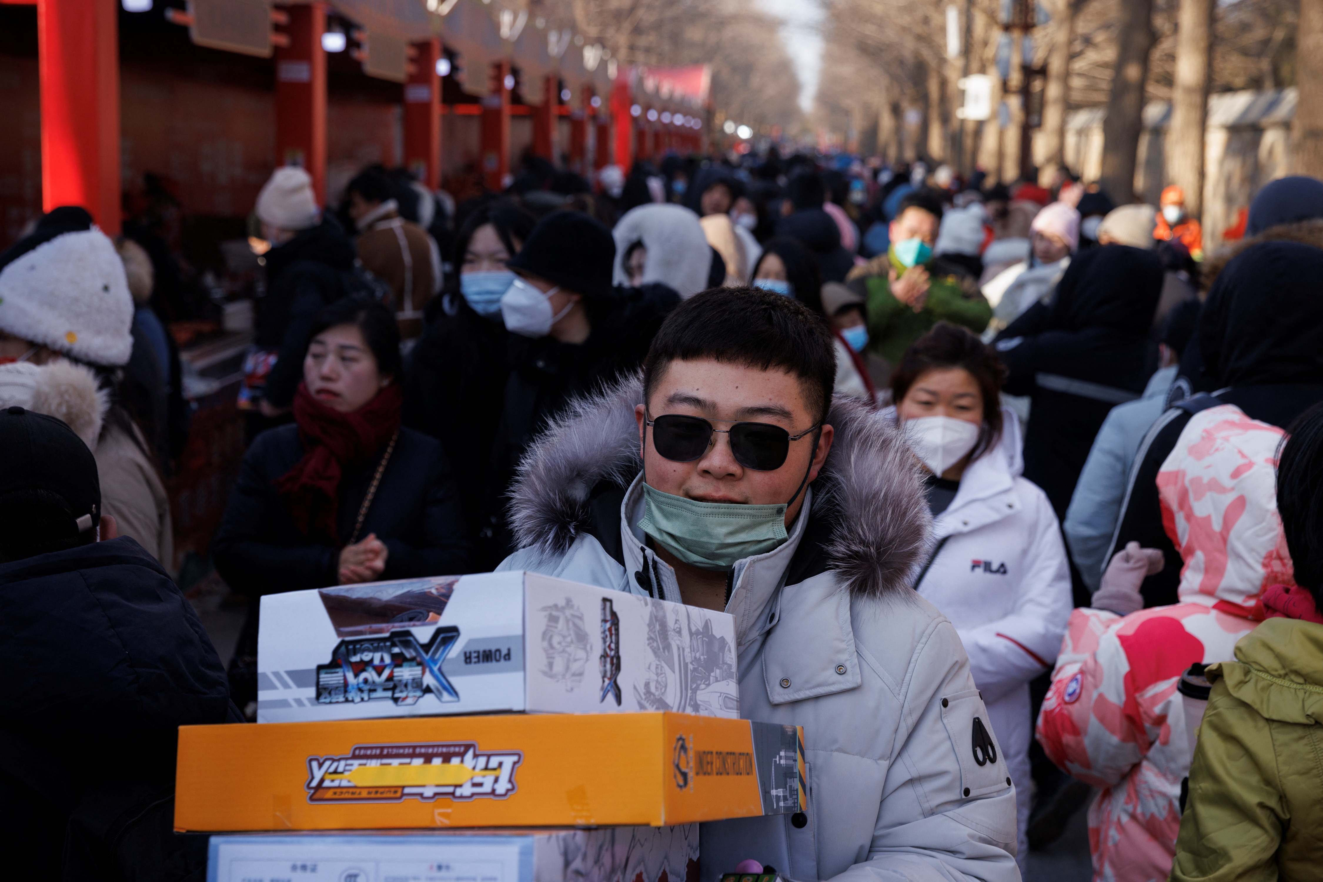 Una persona lleva cajas de juguetes a través de una multitud en el parque Yuanmingyuan durante las celebraciones de la Fiesta de la Primavera y el Año Nuevo Lunar en Beijing, China, 23 de enero de 2023. REUTERS/Thomas Peter/Archivo