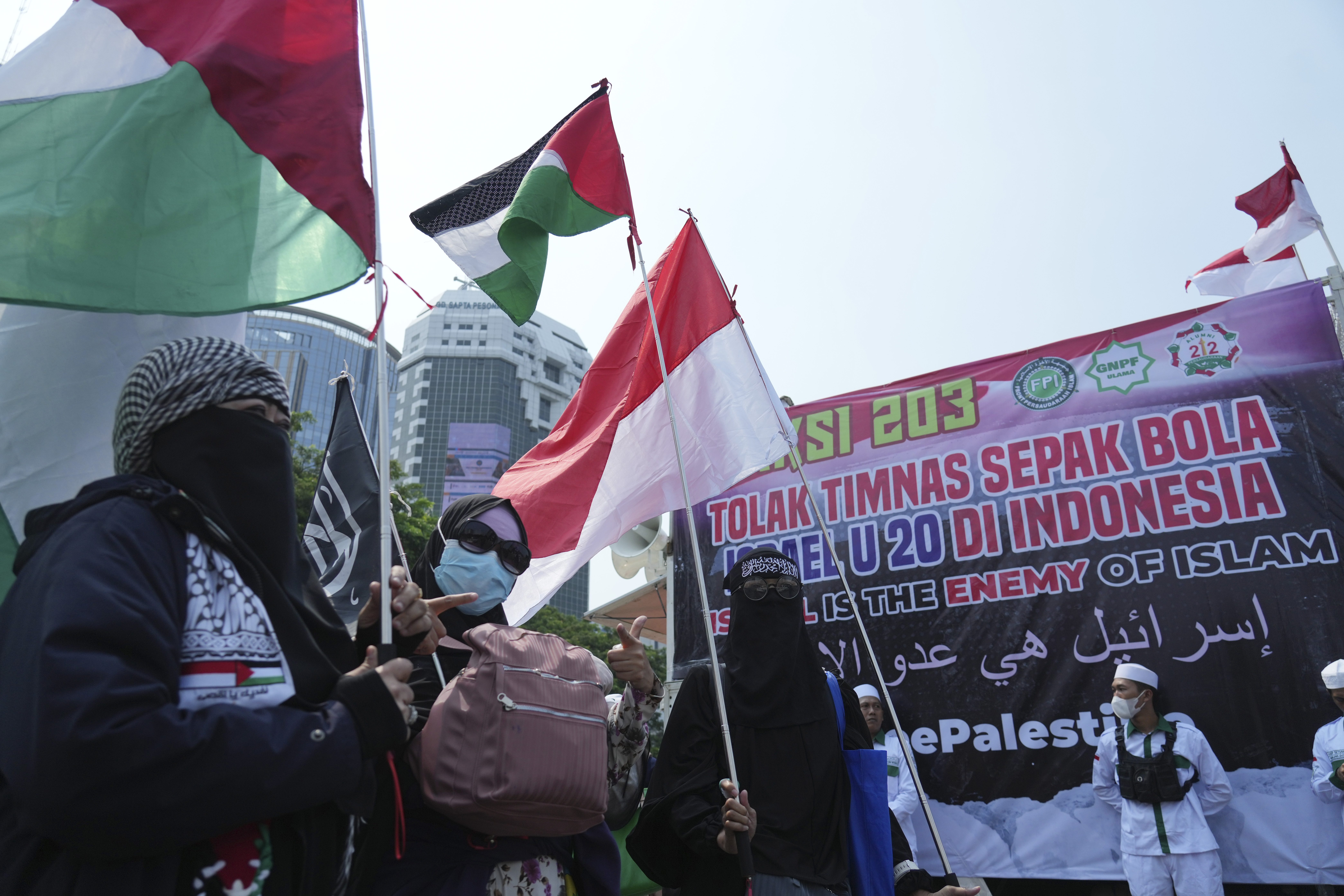 In this Monday, March 20, 2023 photo, protesters with the Palestinian flag march in Jakarta, Indonesia.  On Sunday, March 26, 2023, FIFA postpones the draw for the U-20 World Cup because Indonesia opposes the participation of Israel, a country with which it does not have diplomatic relations. (AP Photo/Achmad Ibrahim)