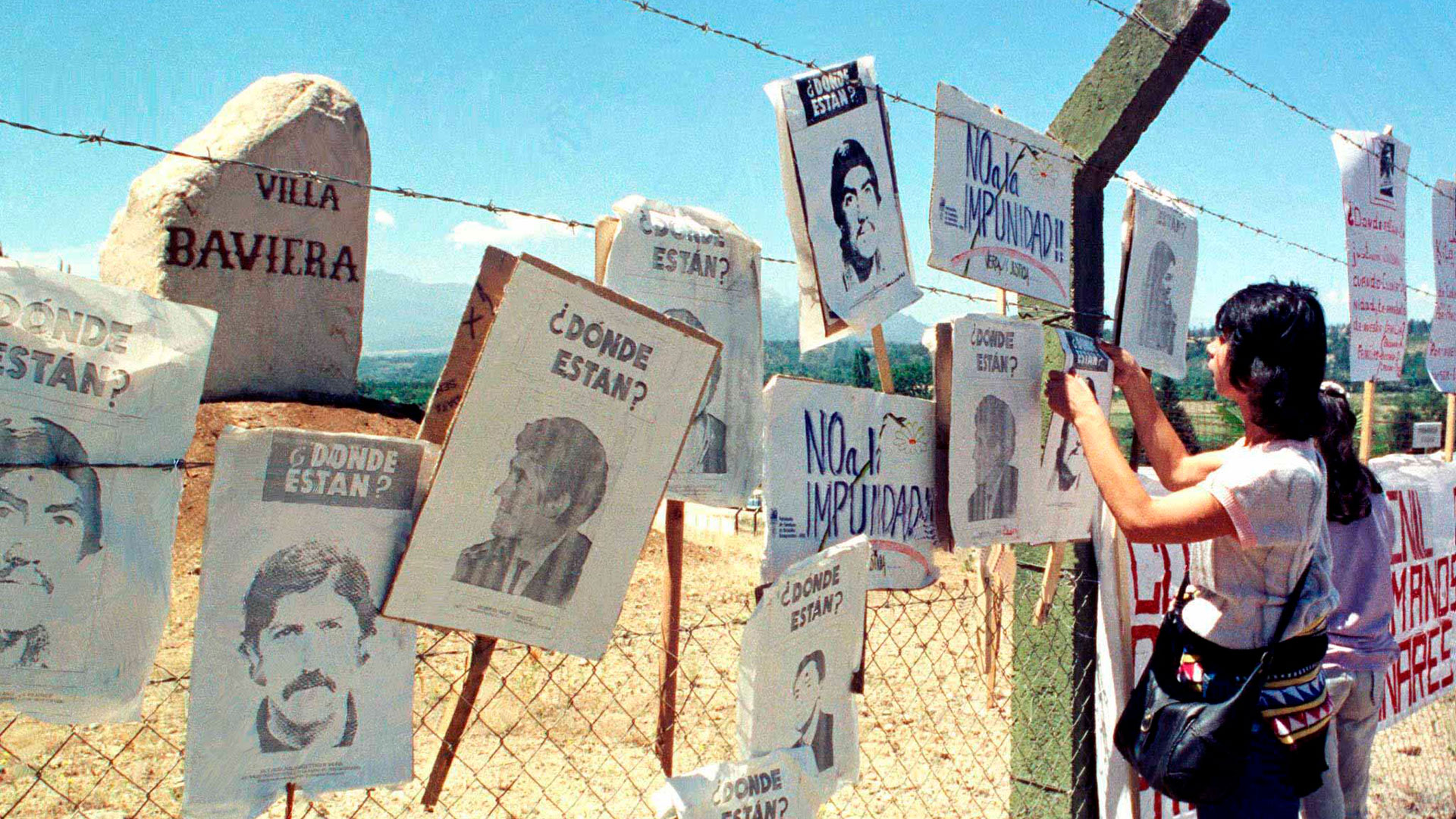 Una mujer cuelga fotografías de desaparecidos en Parral, a 300 kilómetros al sur de Santiago de Chile. Durante la dictadura de Pinochet, la Colonia Dignidad se convirtió en un Centro Clandestino de Detención 