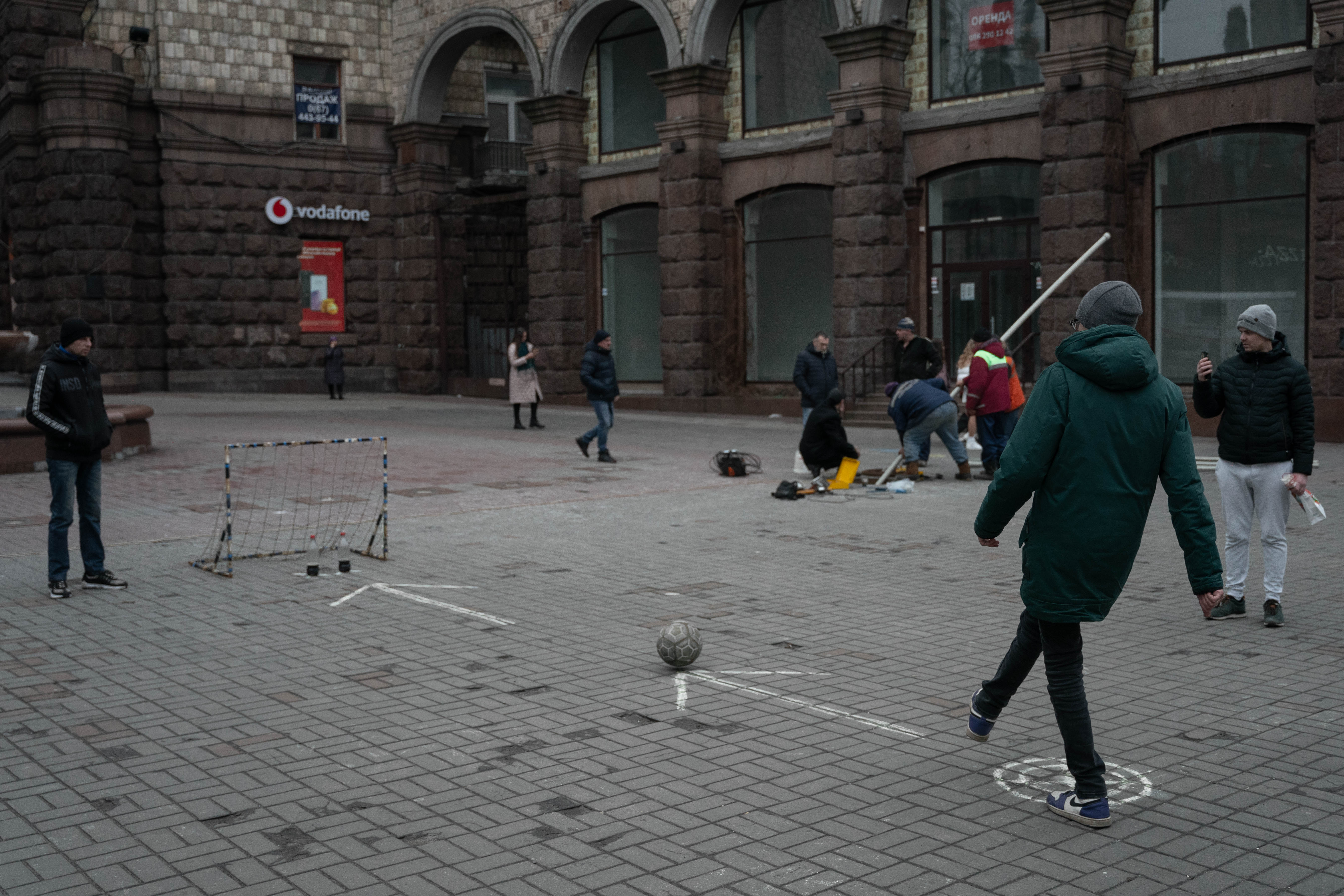 Jovenes tratan de meter un gol sin tirar las botellas, en el centro de Kiev