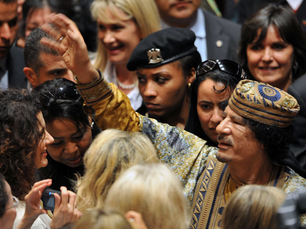 El gesto típico de Khadafi cuando "elegía" a una mujer: le colocaba la mano sobre su cabeza. Detrás del dictador, una de las guardaespaldas femeninas, que también eran esclavas sexuales AFP