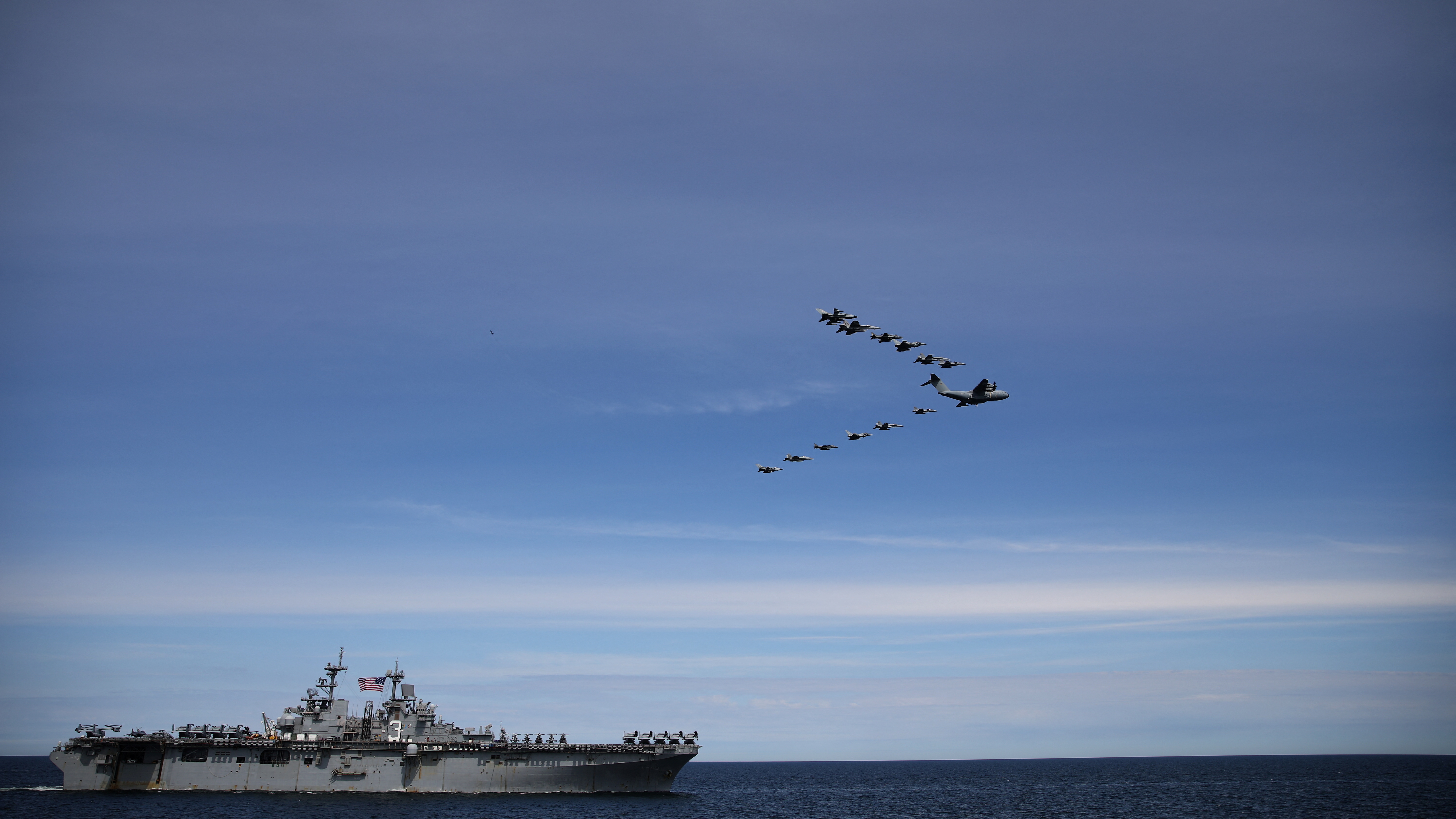 A German transport plane leads a multinational fighter jet formation over the U.S. navy Wasp-class amphibious assault ship USS Kearsarge (LHD 3) during the first event of the Baltops 22 exercise in Baltic Sea, June 6, 2022. Picture taken June 6, 2022.  REUTERS/Stoyan Nenov