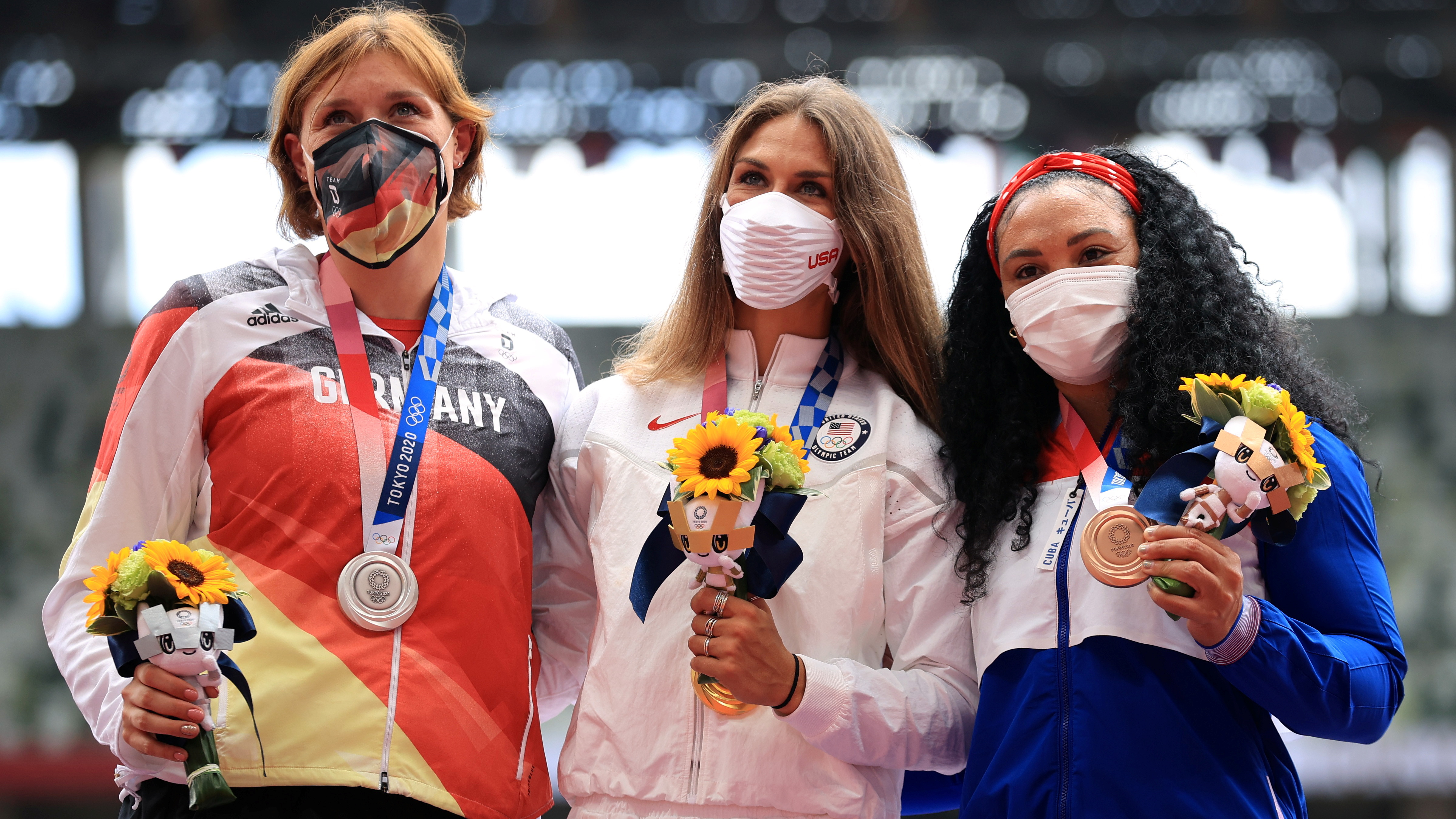 Tokyo 2020 Olympics - Athletics - Women's Discus Throw - Medal Ceremony - Olympic Stadium, Tokyo, Japan - August 3, 2021. Gold medallist, Valarie Allman of the United States poses on the podium with silver medallist, Kristin Pudenz of Germany and bronze medallist, Yaime Perez of Cuba as they all wear protective face masks REUTERS/Hannah Mckay