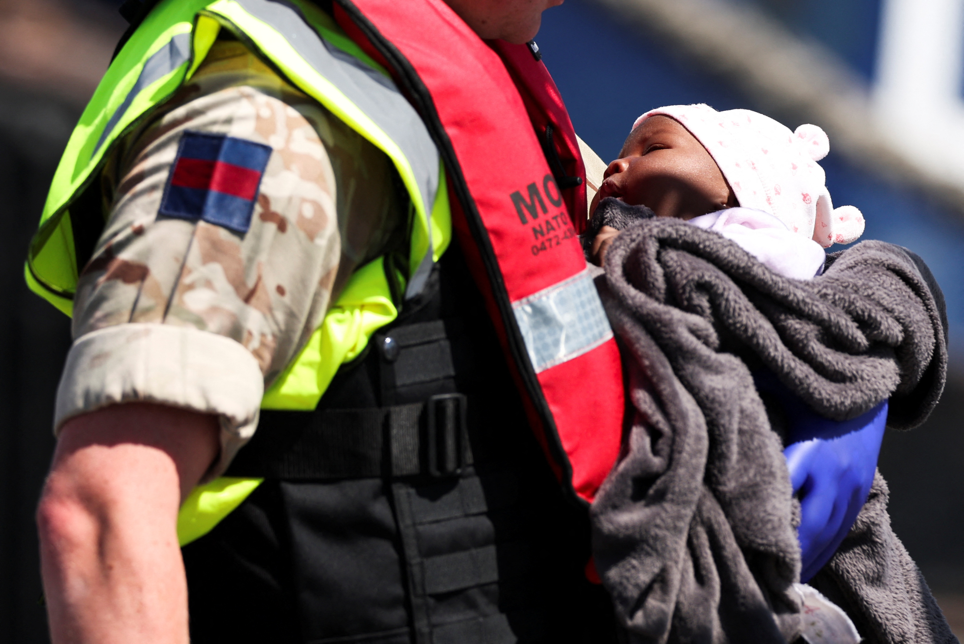 En soldat bærer en gutt etter en redning i kanalen (Reuters).