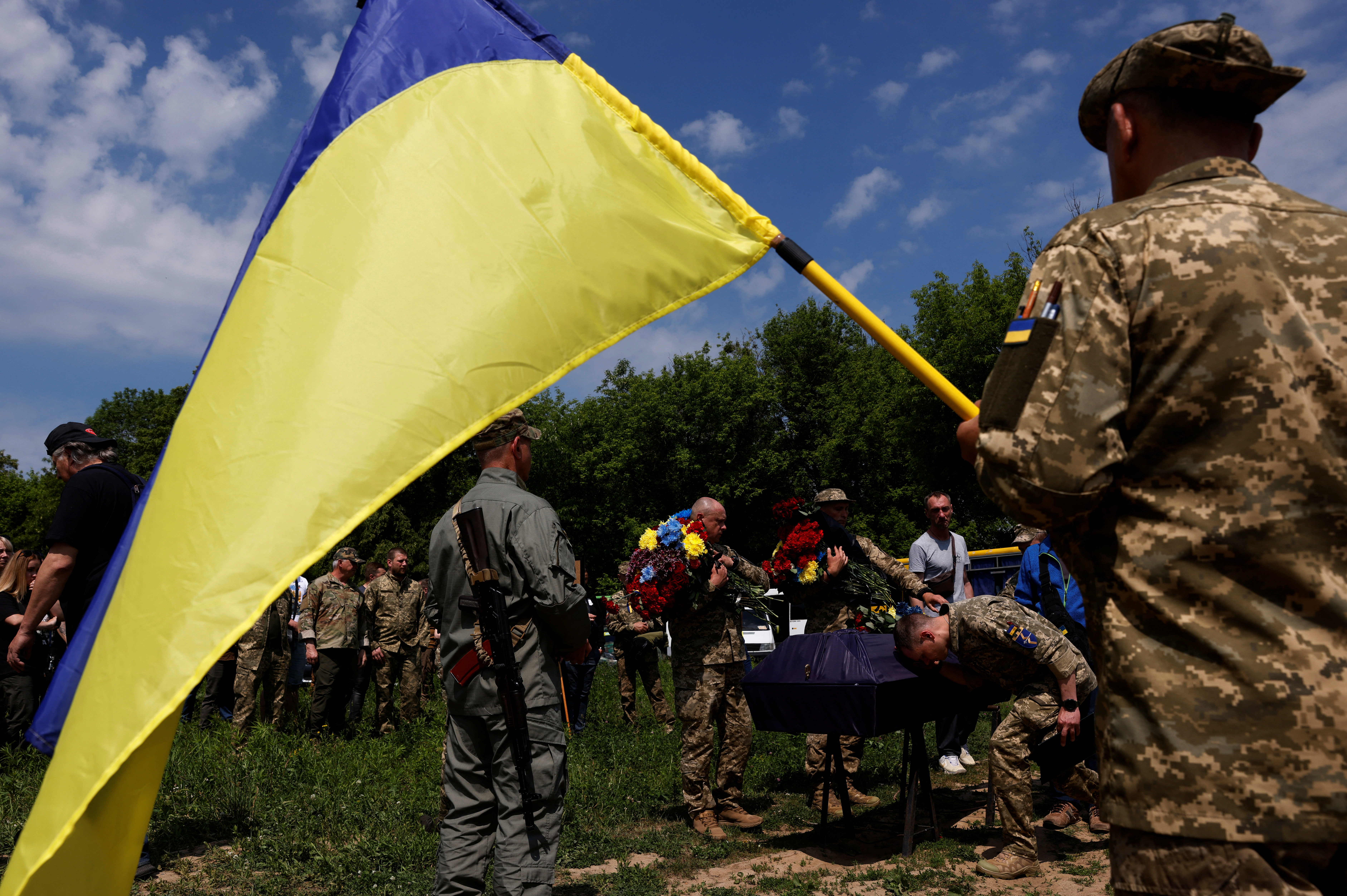 Un soldado rinde homenaje a su compañero Zviryk Valentyn, quien fue asesinado por una mina antitanque durante una misión de reconocimiento en la región de Kharkiv, en un cementerio en Kyiv, Ucrania, el 2 de junio de 2022. (REUTERS/Edgar Su)