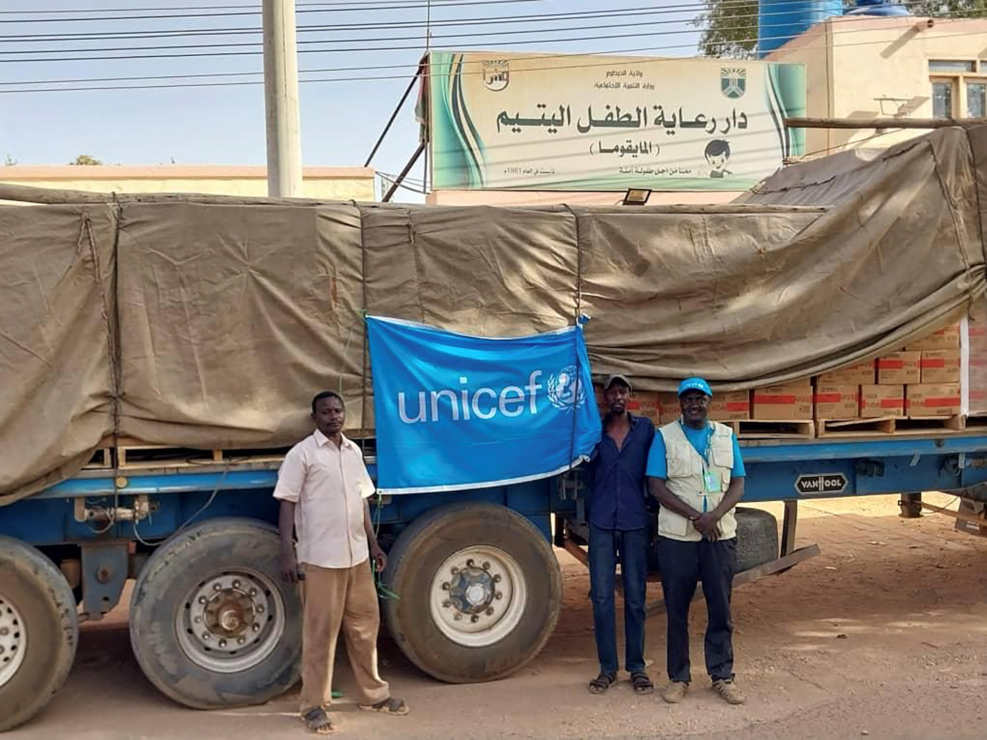 Las personas se paran junto a una bandera de UNICEF adherida a un camión, en Jartum, Sudán, en esta imagen del folleto publicada el 18 de mayo de 2023. Nazim Hassan/Handout vía REUTERS