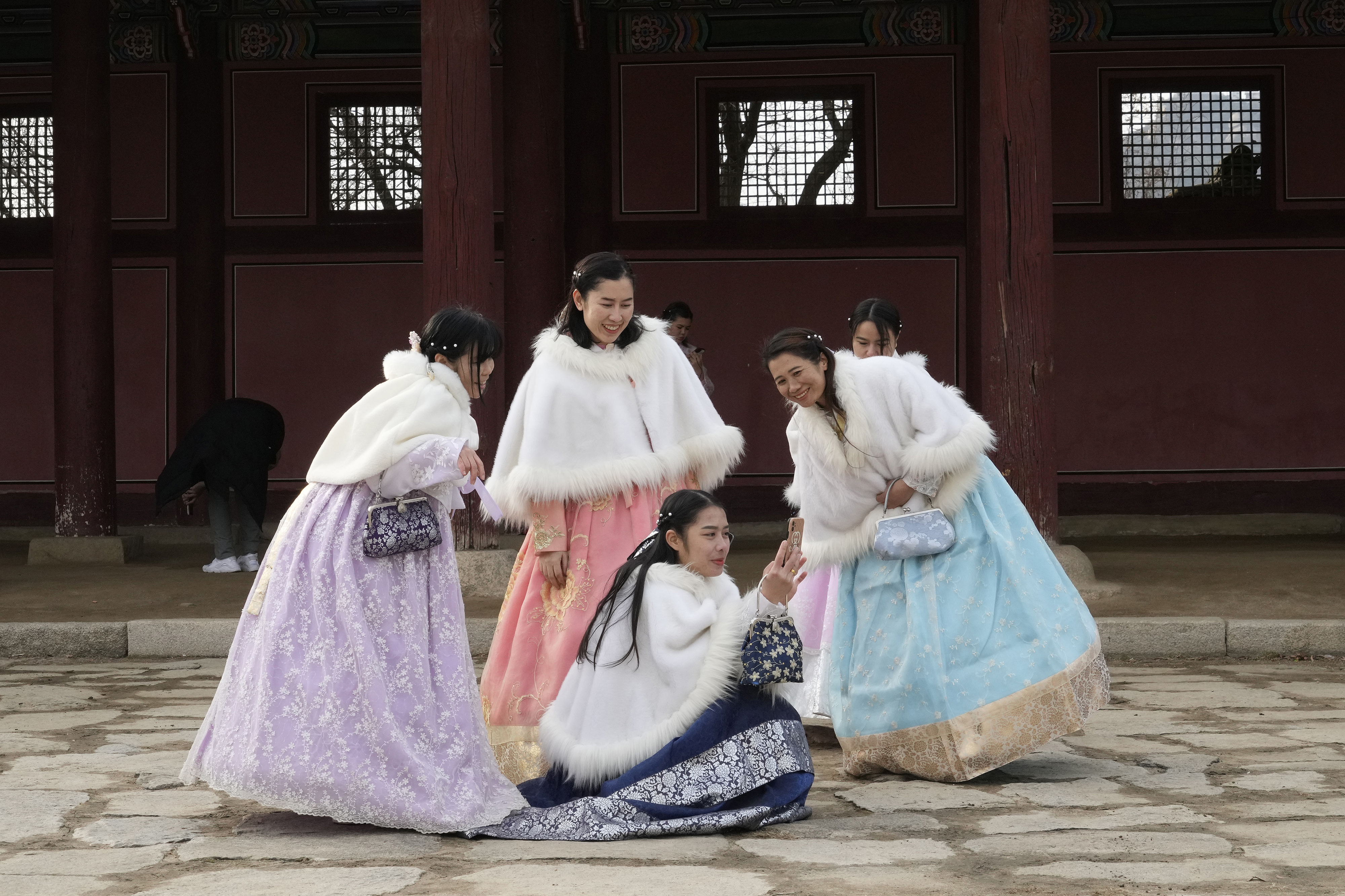People in traditional hanbok attire look at a cell phone during their visit to celebrate Lunar New Year at Gyeongbok Palace, which was the main royal palace of the Joseon Dynasty and one of South Korea's best-known landmarks, in Seoul, South Korea. South, on Sunday, Jan. 22, 2023. (AP Photo/Ahn Young-joon)