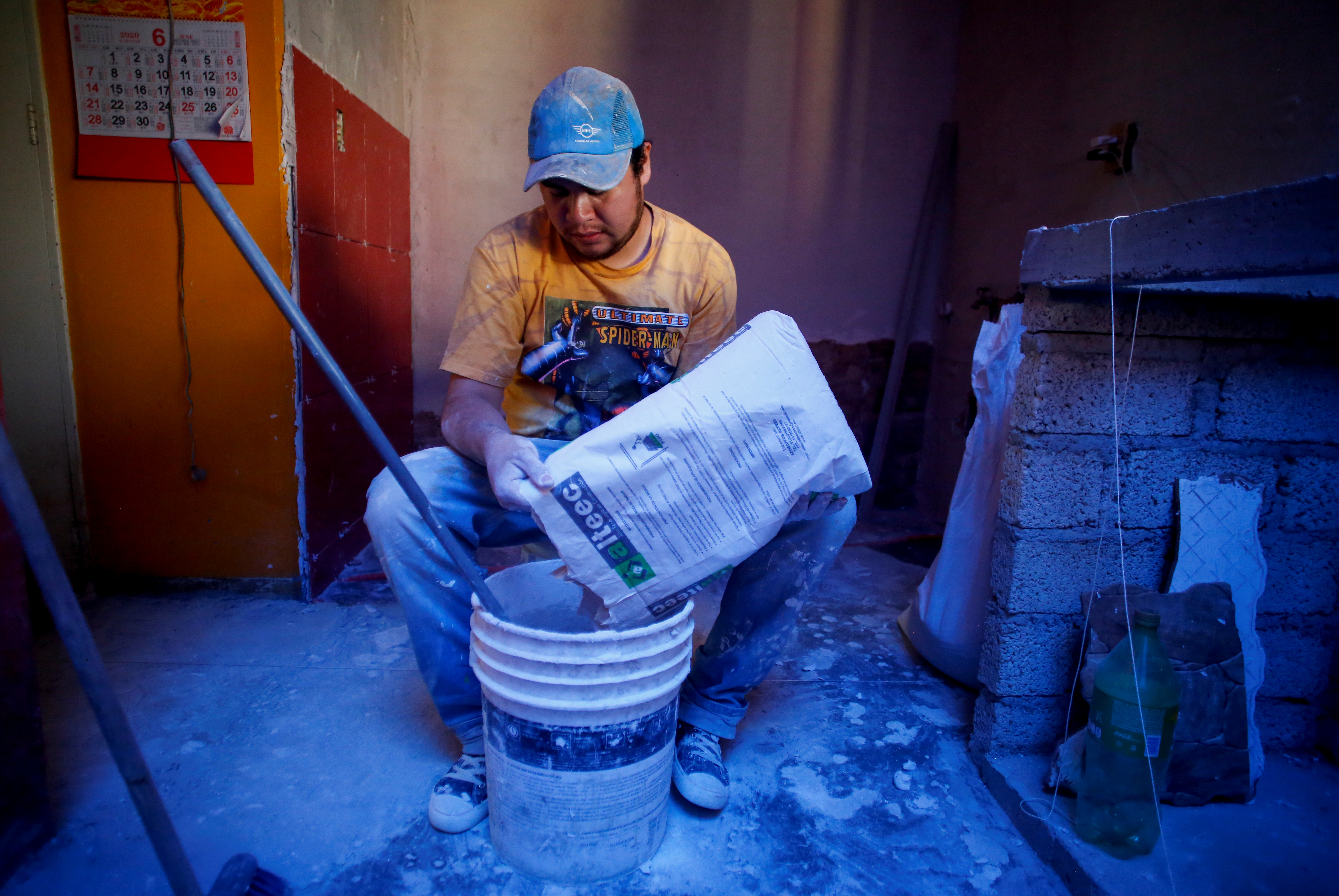 Miguel Flores Torres vierte cemento mientras remodela una casa en Villa Olímpica, Ciudad de México, México, 17 de junio de 2020. Foto: REUTERS / Gustavo Graf.