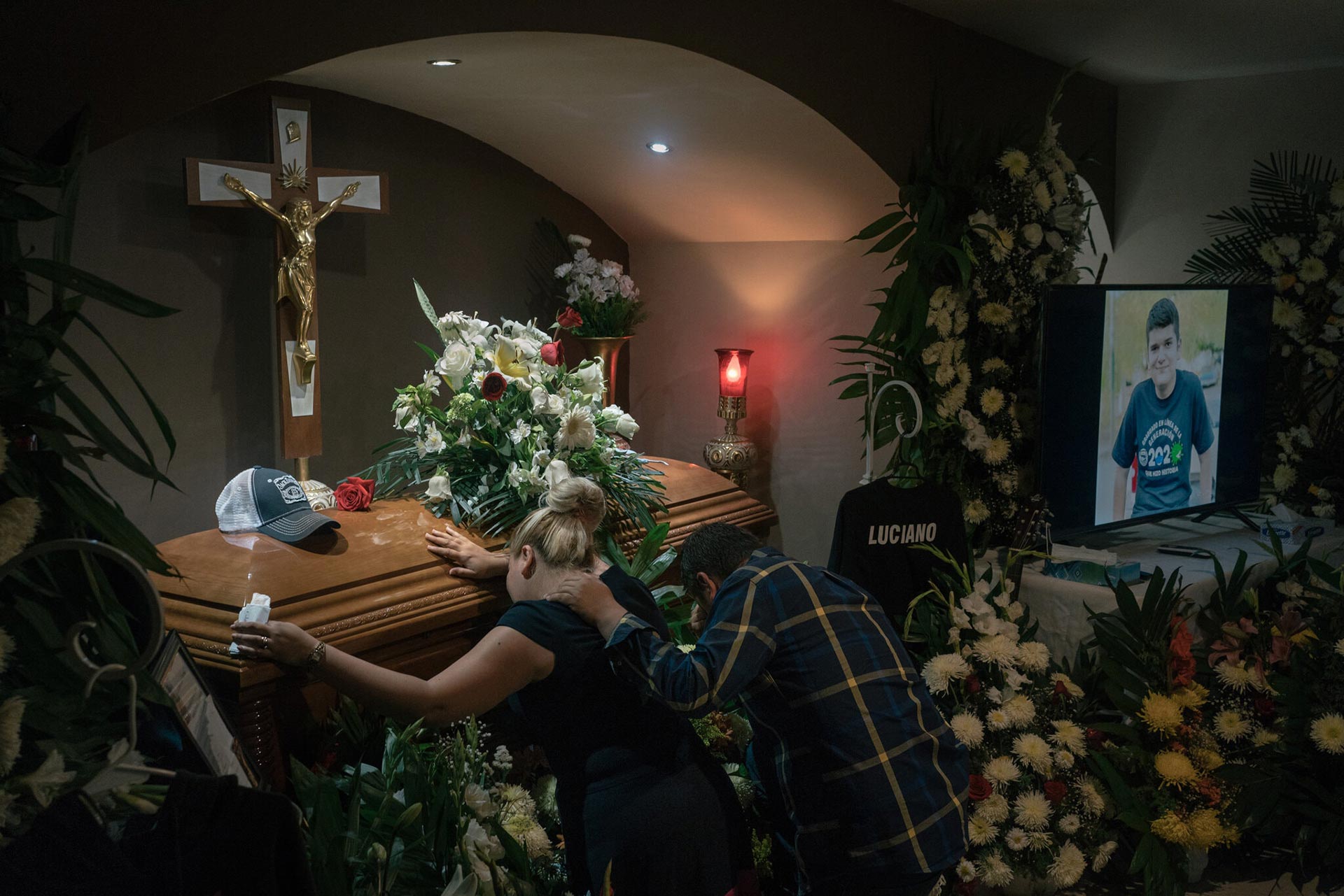 Anabel Garza Rivera y Luciano Leal Vela arrodillados ante el féretro de su hijo asesinado