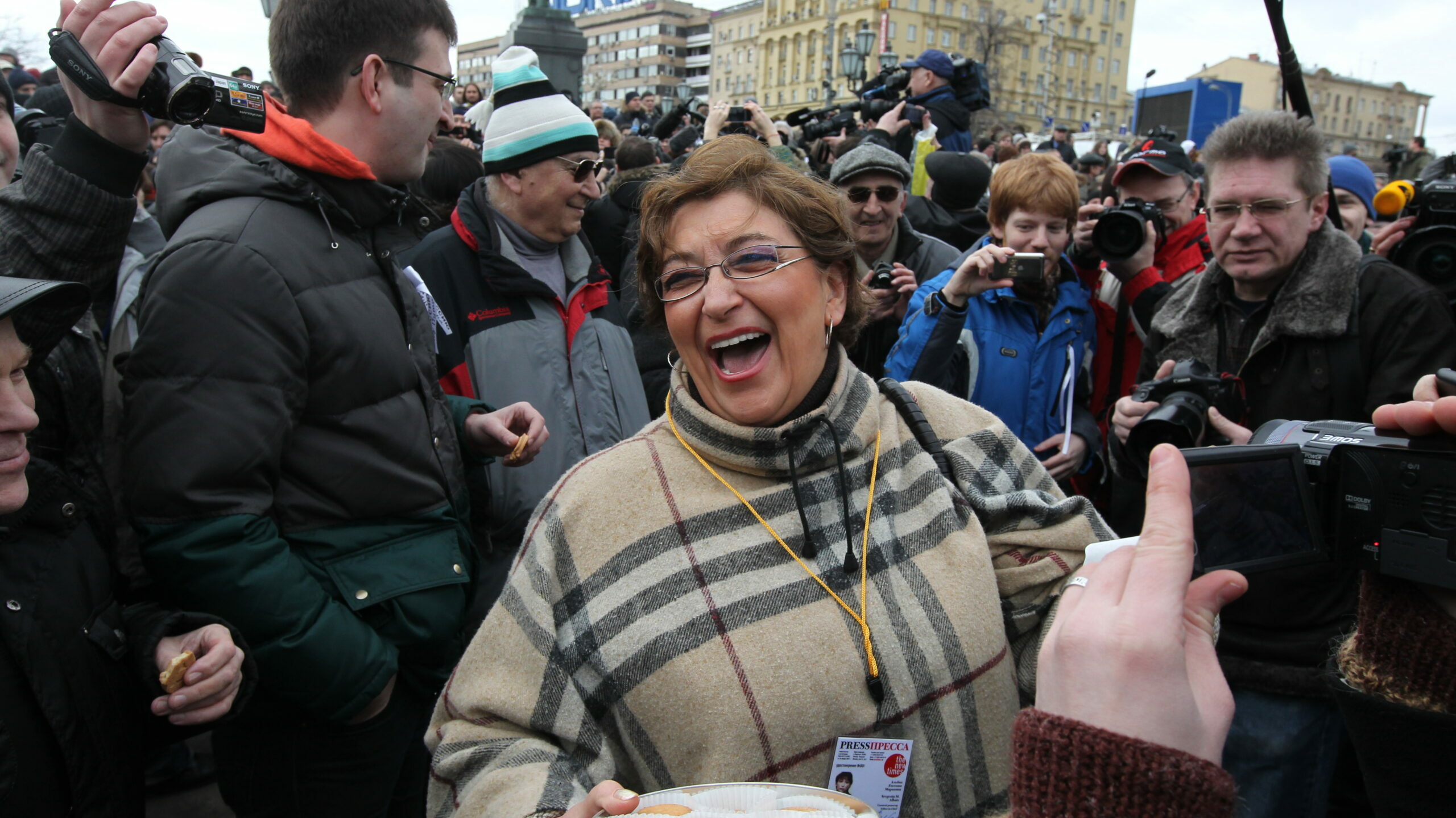 Evgenia Markovna Albats, la decana del periodismo independiente ruso, bromeando con sus colegas en una protesta contra la guerra en la plaza Pushkinskaya de Moscú realizada en marzo. (Sasha Mordovets/Reuters)