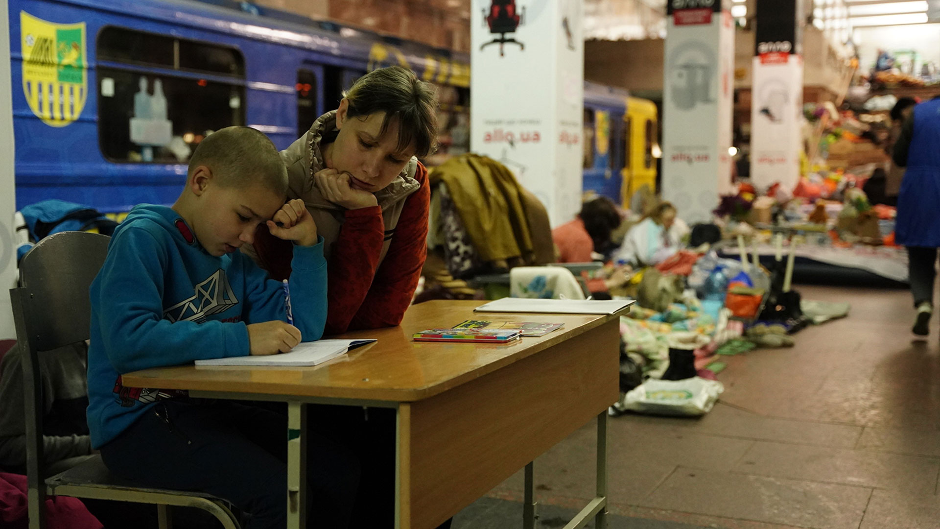 Un niño toma clase de su madre en la estación de subte Heroiv Pratsi, que se usa en Kharkiv como refugio desde la invasión de Rusia a Ucrania. (Franco Fafasuli)