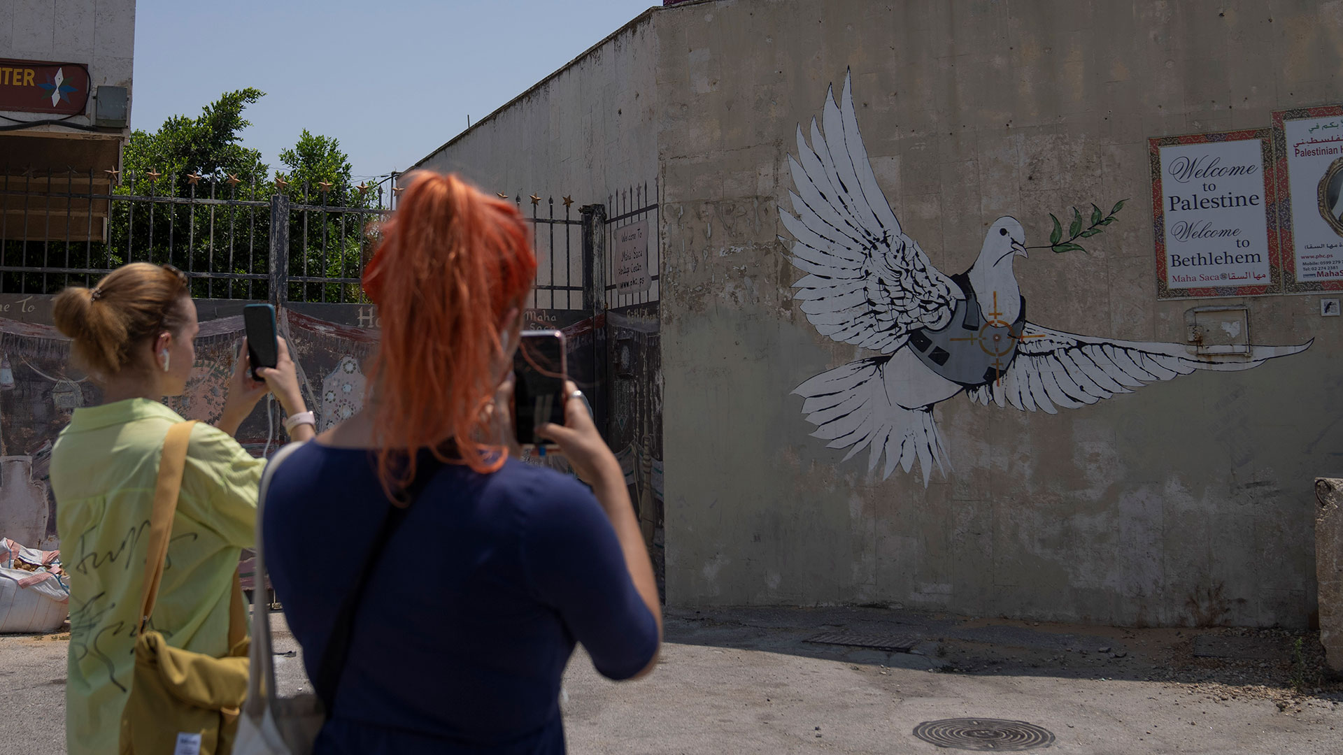 Turistas toman fotos de un mural de Banksy en la ciudad de Belén, Cisjordania (AP/Nasser Nasser)