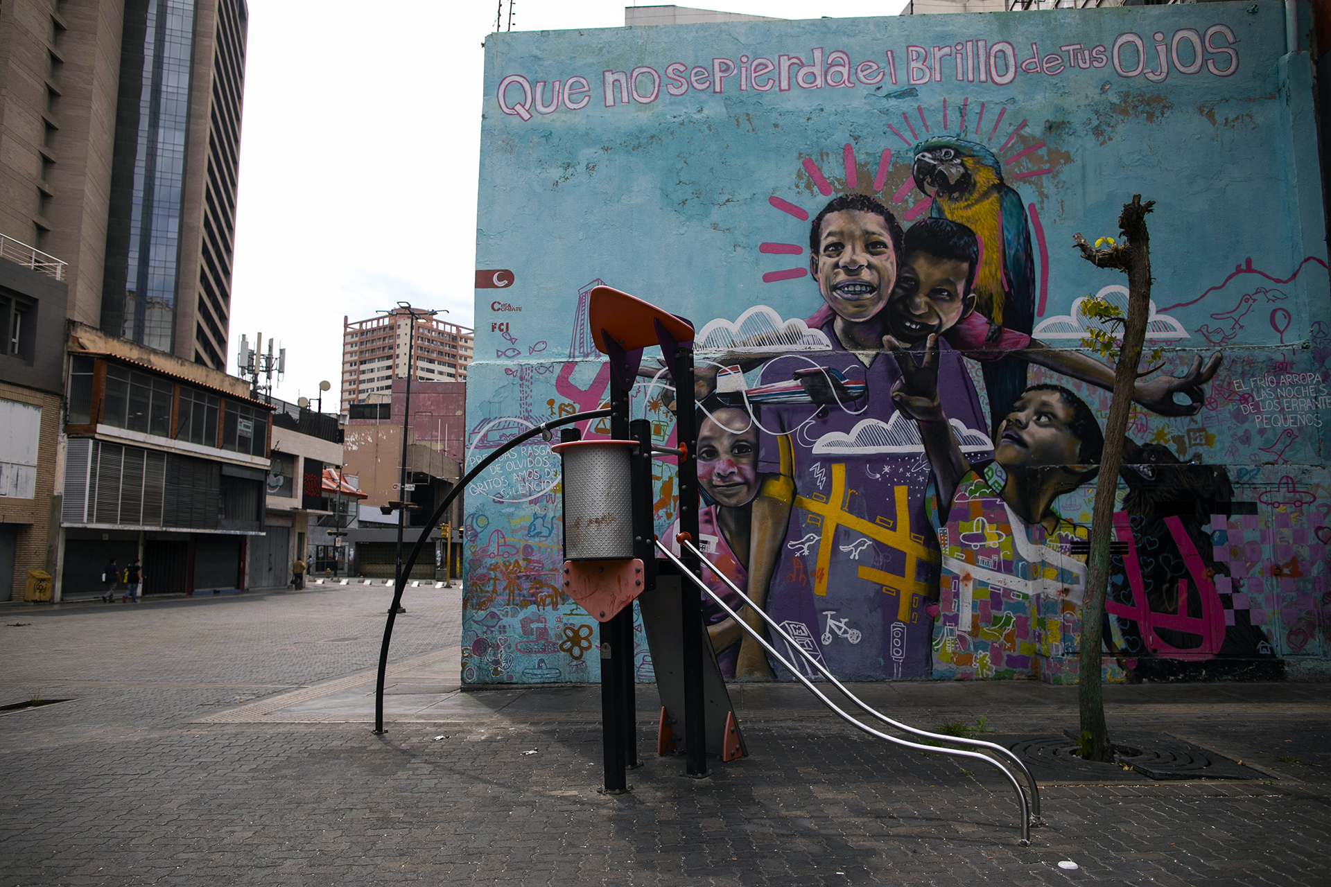 Un parque, con un mural con el lema