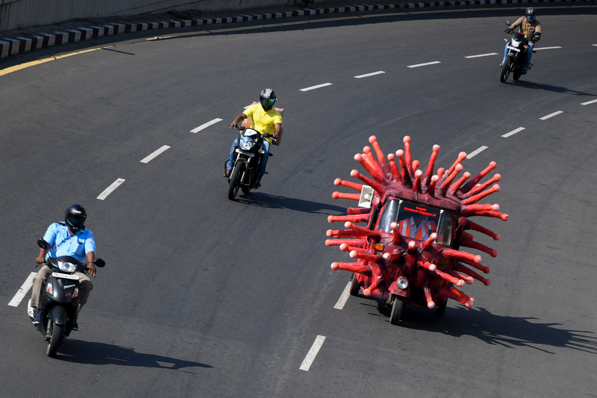 Un trabajador municipal de la salud conduce un auto-rickshaw decorado como una imagen de coronavirus a lo largo de una carretera para concienciar sobre el coronavirus COVID-19 en Chennai el 23 de abril de 2020. (Foto de Arun SANKAR / AFP)
