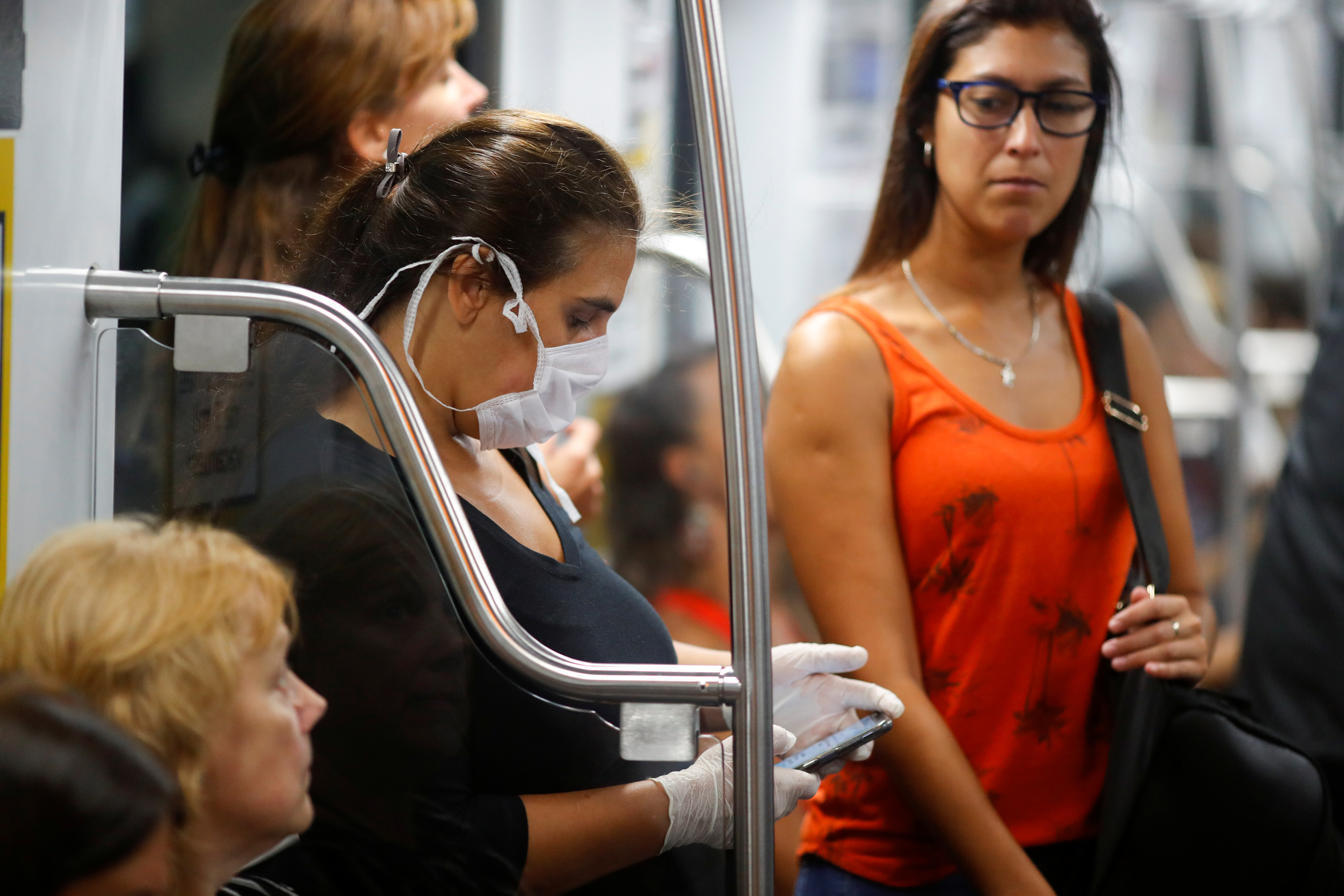 Una mujer con barbijo y guantes usa su smartphone en el subte de  Buenos Aires (REUTERS/Agustin Marcarian)
