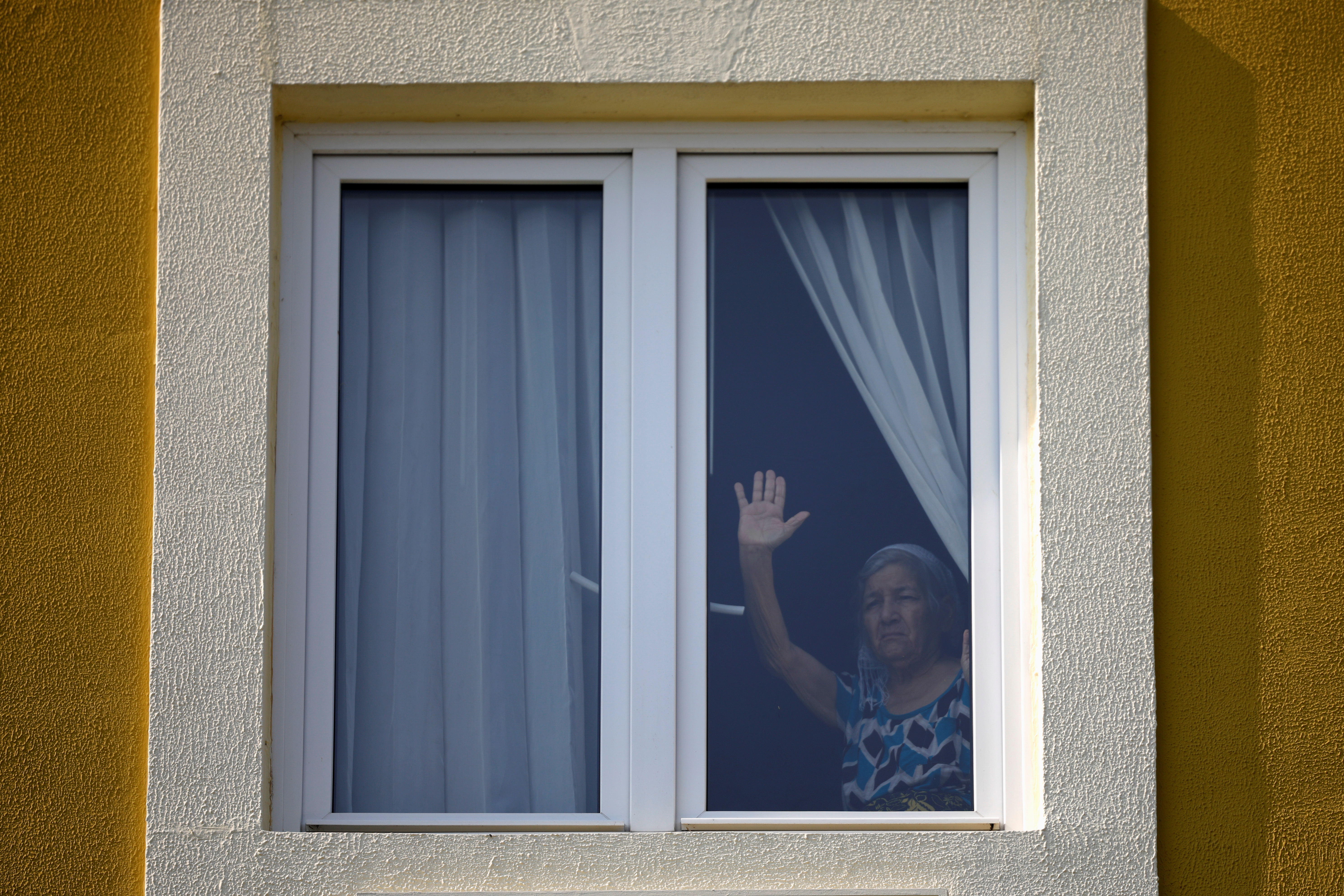 Una paciente aislada en un hotel, utilizada como centro de cuarentena, reacciona mientras escucha a un grupo de mariachis como parte de la celebración del Día de la Madre mientras el gobierno toma medidas cada vez más estrictas para prevenir la propagación de la enfermedad por coronavirus (COVID-19), en Antiguo Cuscatlán, San Salvador, El Salvador 10 de mayo de 2020. (Foto: REUTERS/Jose Cabezas)