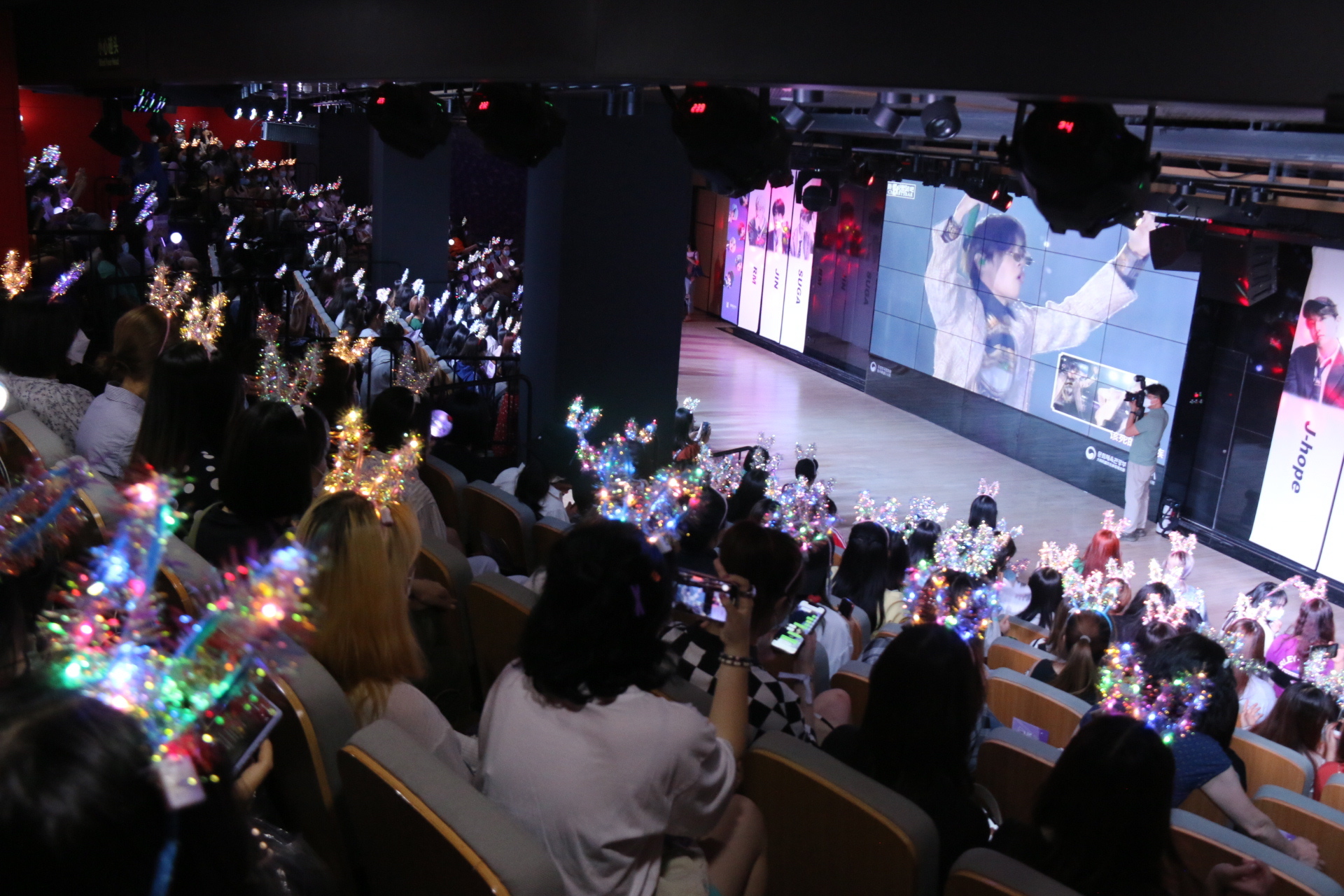 Fans de BTS viendo un vídeo del grupo en un evento