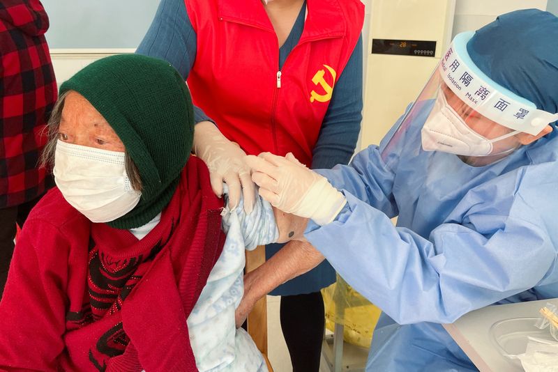 Demande de vaccin à une femme âgée à la périphérie de Shanghai (Reuters)