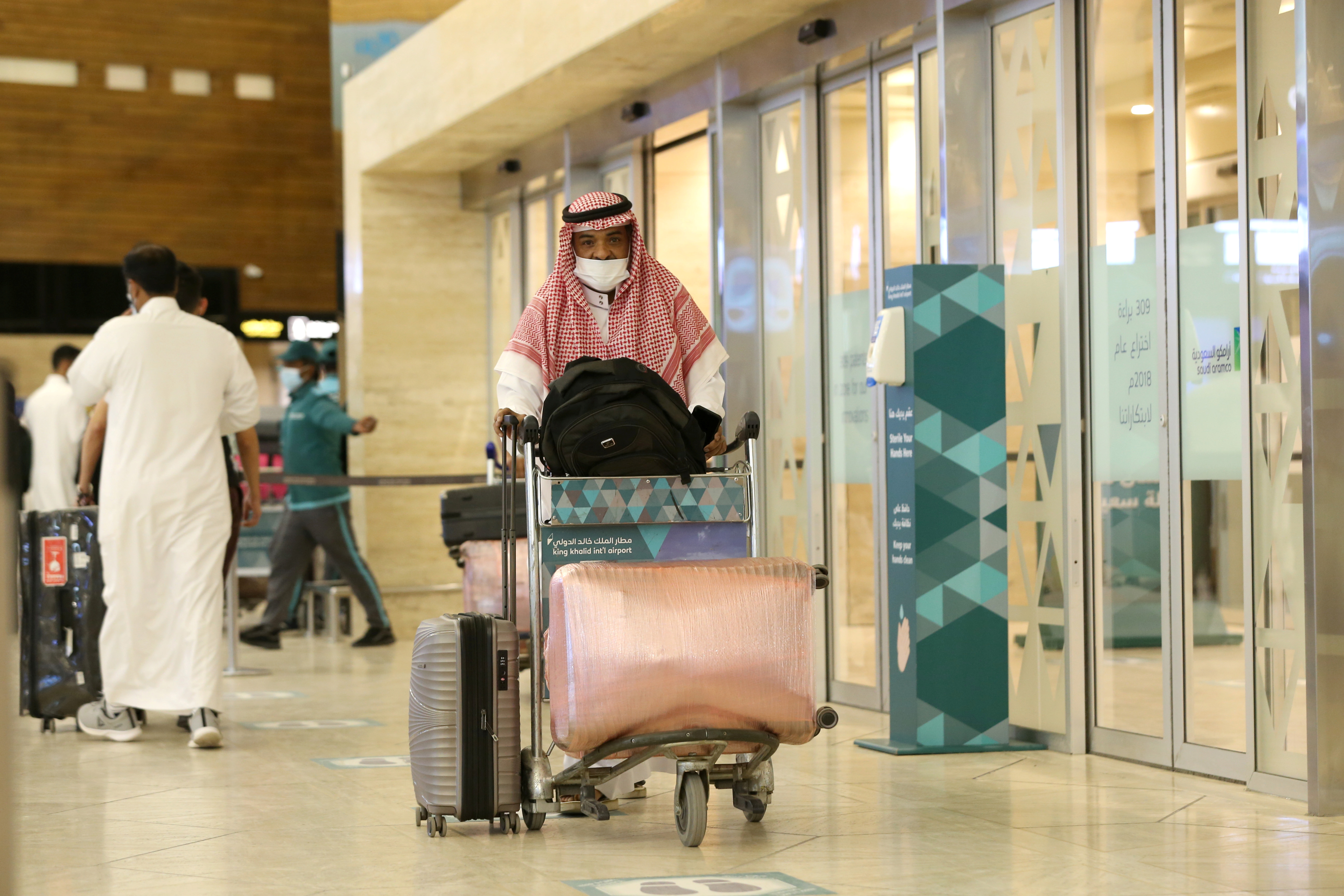 Se ve a un hombre saudí con una mascarilla con su equipaje cuando llega al Aeropuerto Internacional Rey Khalid, luego de que las autoridades sauditas levantaran la prohibición de viajar a sus ciudadanos después de catorce meses debido a las restricciones del Coronavirus (COVID-19), en Riad, Arabia Saudita. 
 REUTERS/Ahmed Yosri