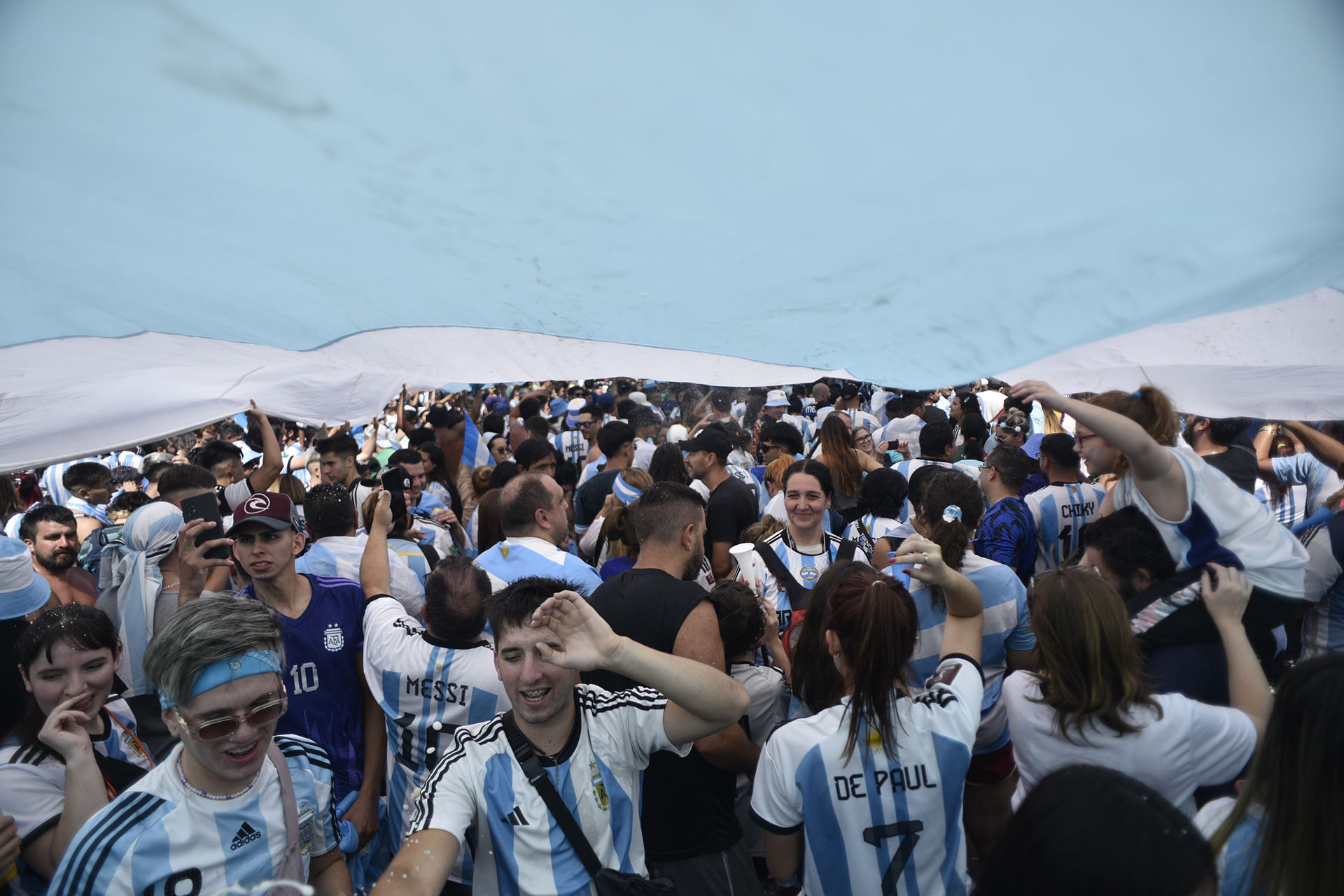 Un poco de sombra bajo la bandera argentina para sostener la fiesta a pesar del intenso calor de la tarde 