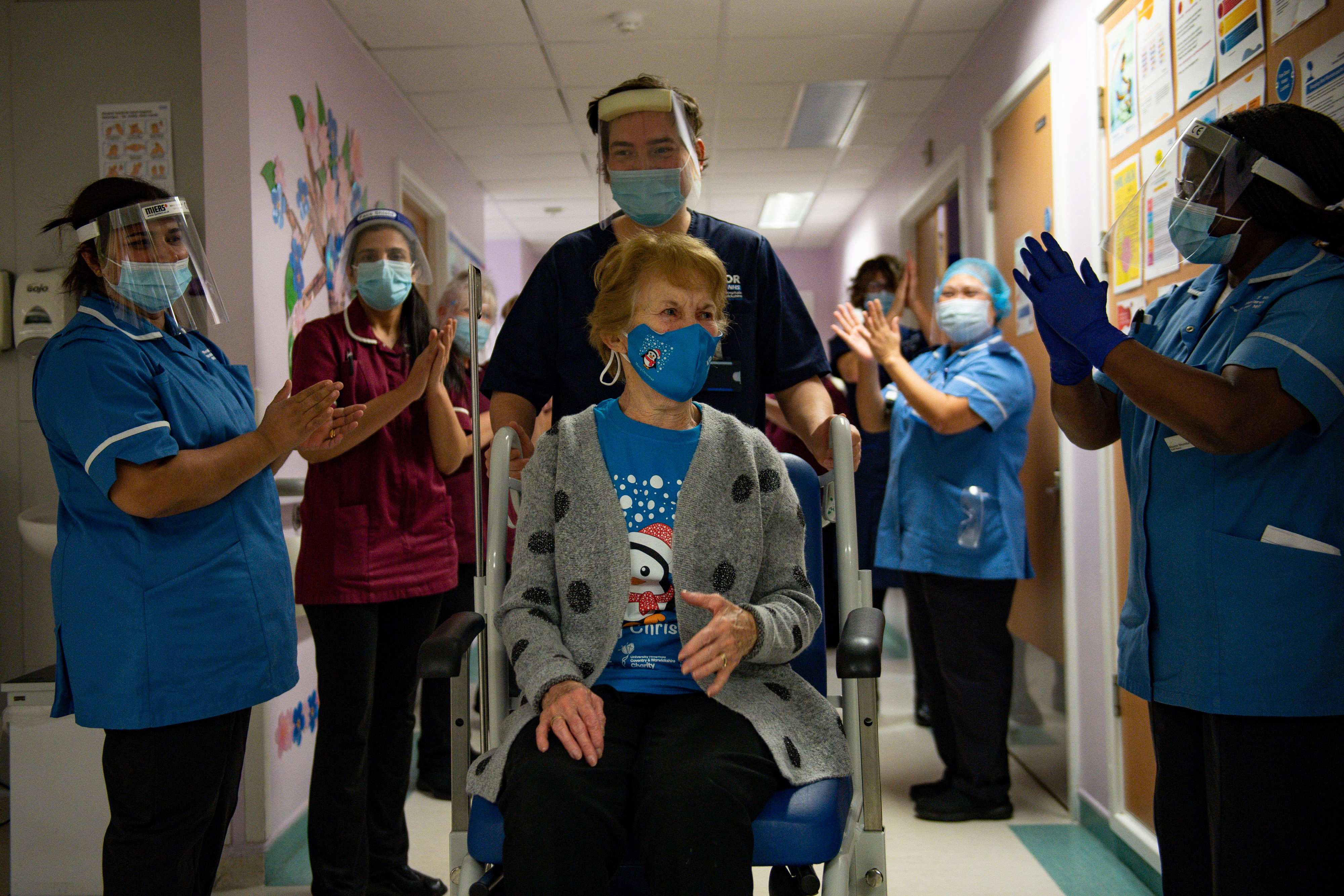 Margaret Keenan, de 90 años es aplaudida por el personal del Hospital Universitario de Coventry, en el Reino Unido. La mujer se convirtió en la primera británica en recibir la dosis de Pfizer contra el coronavirus (Reuters)
