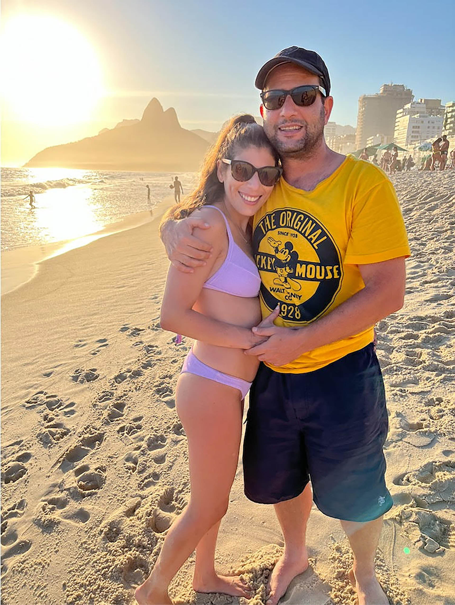 La pareja feliz disfrutando de la caída del sol en Ipanema, Río de Janeiro