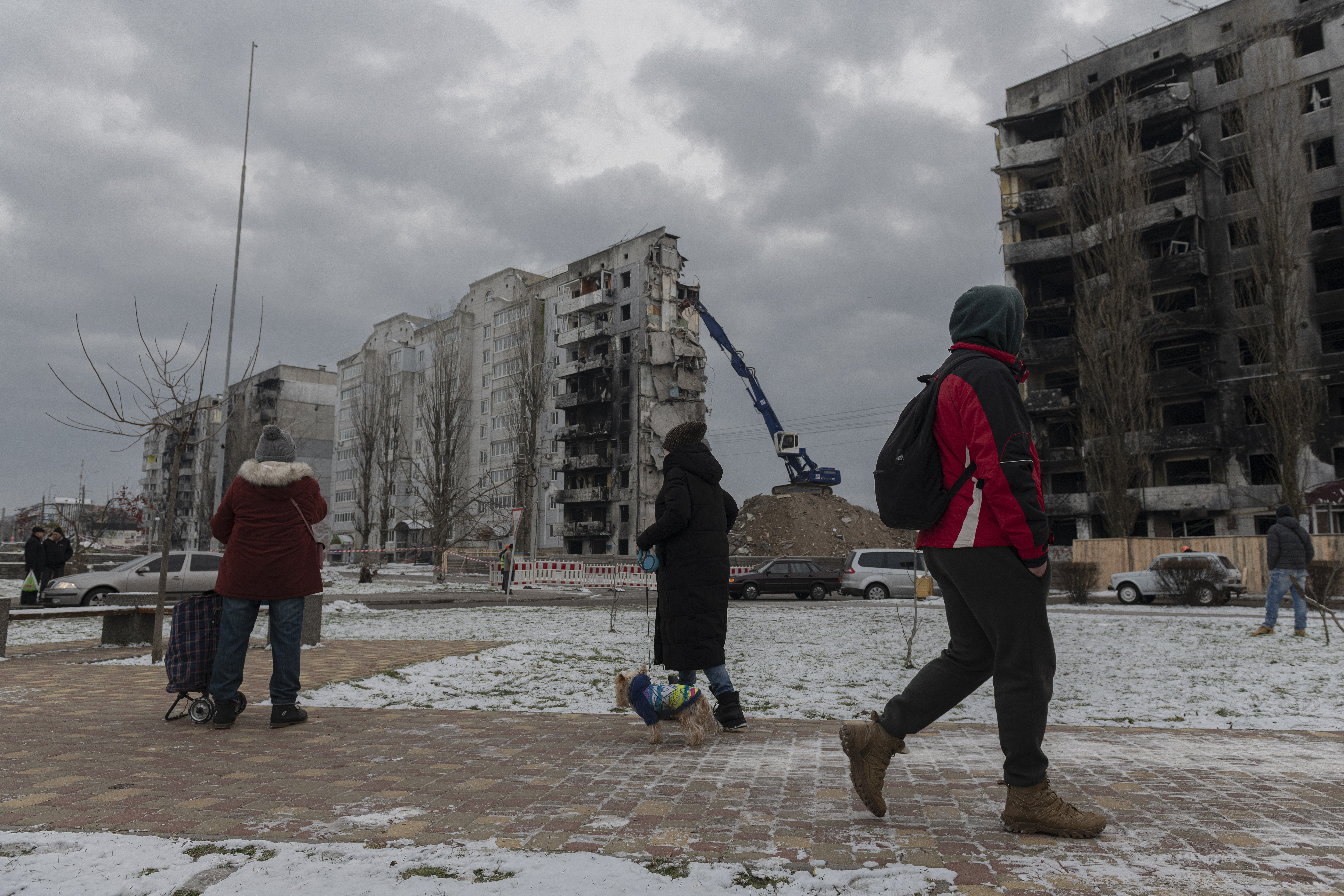 Residentes observan mientras un edificio atacado es desmantelado en Borodyanka, en la región de Kiev, Ucrania