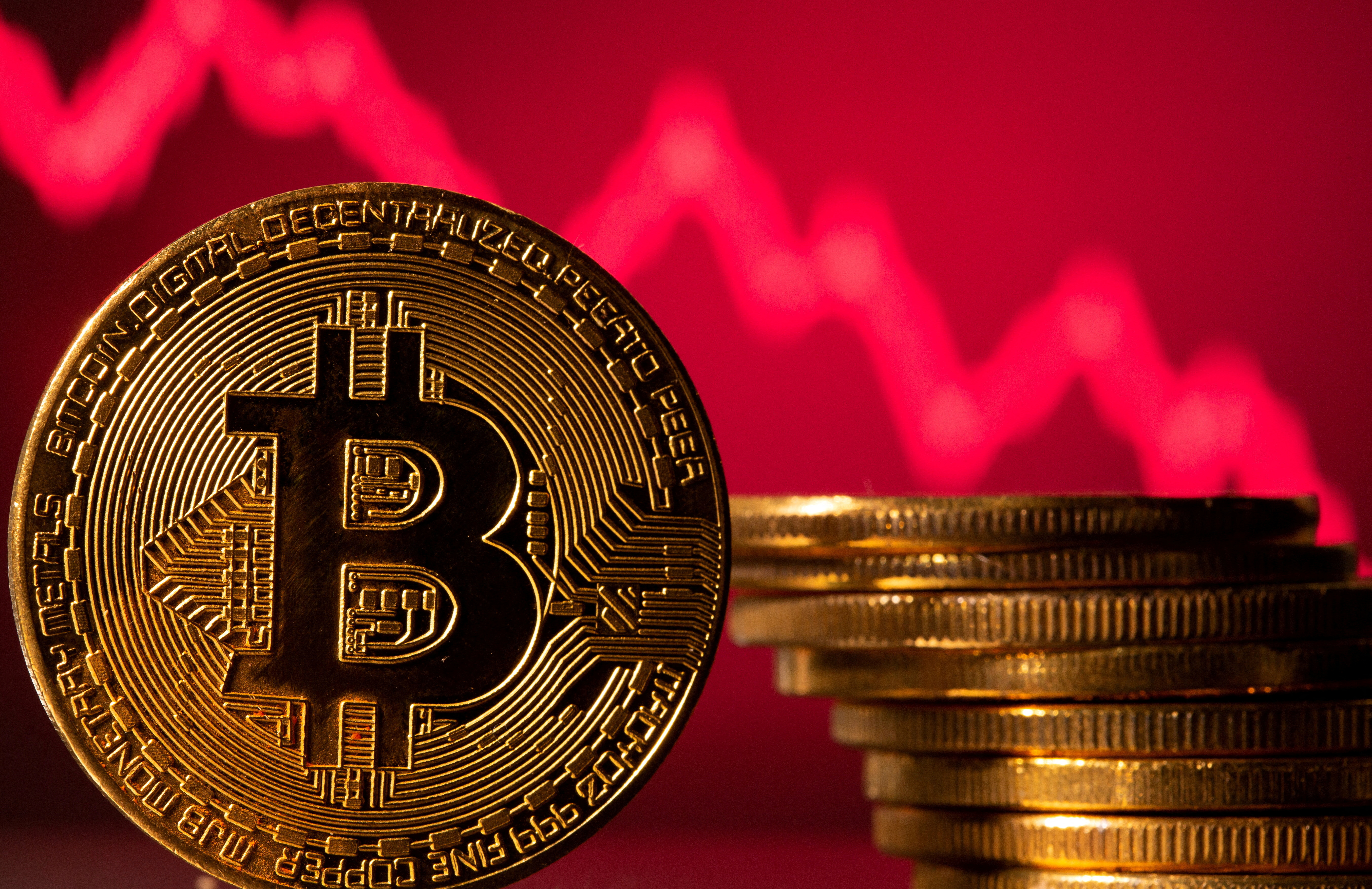 FILE PHOTO: A representation of bitcoin is seen in front of a stock graph in this illustration taken May 19, 2021. REUTERS/Dado Ruvic/Illustration//File Photo
