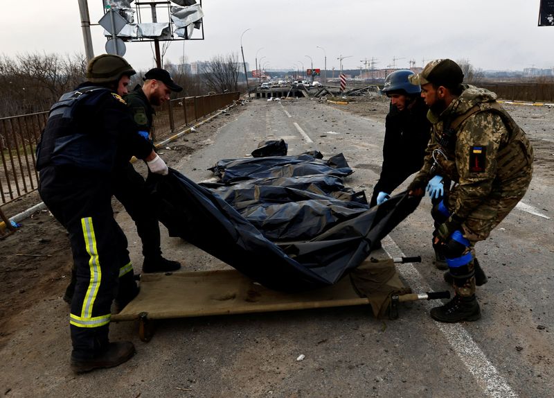 Miembros de los servicios de emergencia llevan los cuerpos de los civiles muertos por los bombardeos rusos para ser trasladados a un depósito de cadáveres en medio de la invasión de Rusia en Ucrania, en Irpin (REUTERS/Zohra Bensemra)