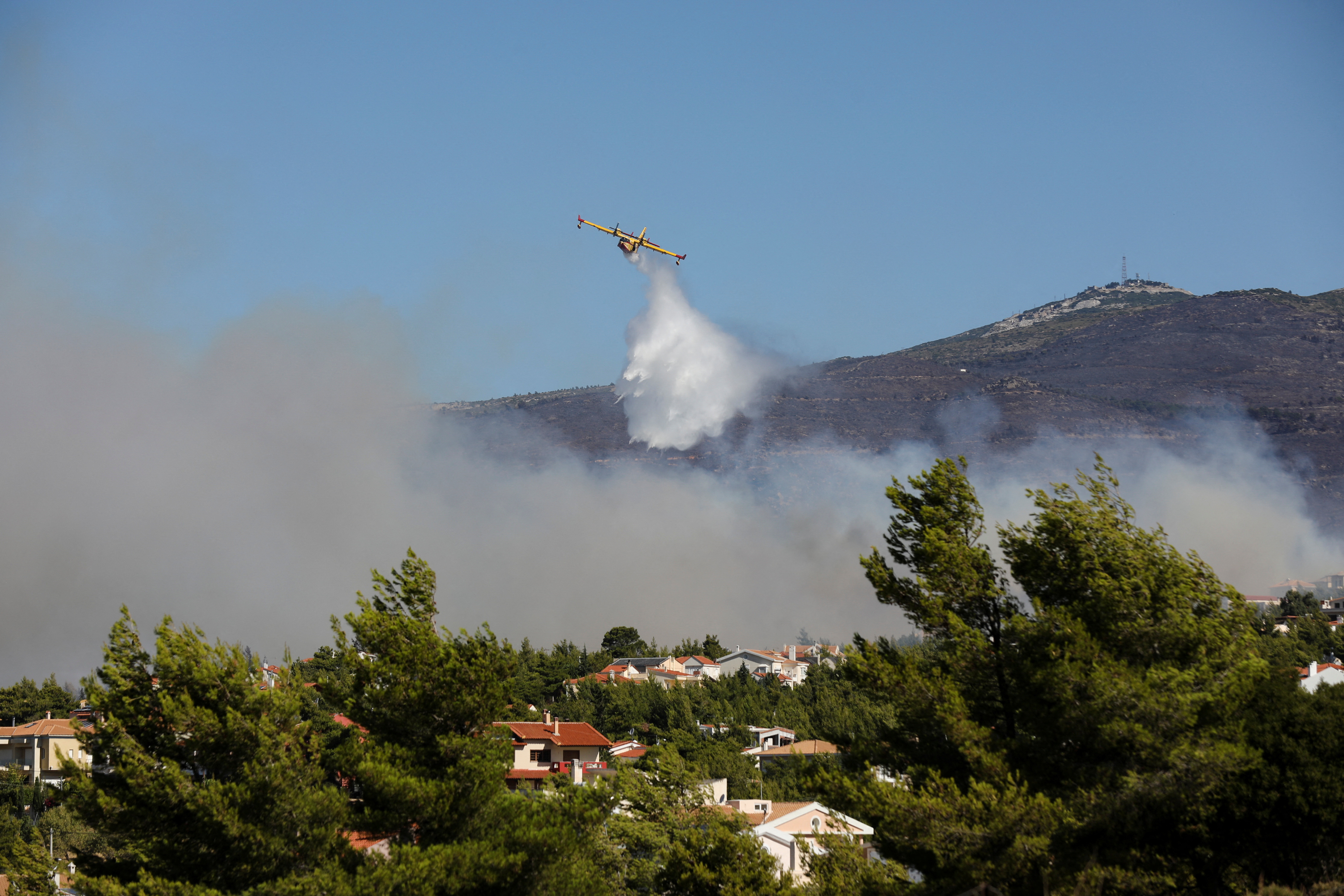 Un avión Canadair lanza agua mientras arde un incendio forestal en el suburbio de Pikermi en Atenas, Grecia, el 20 de julio de 2022. REUTERS/Louiza Vradi