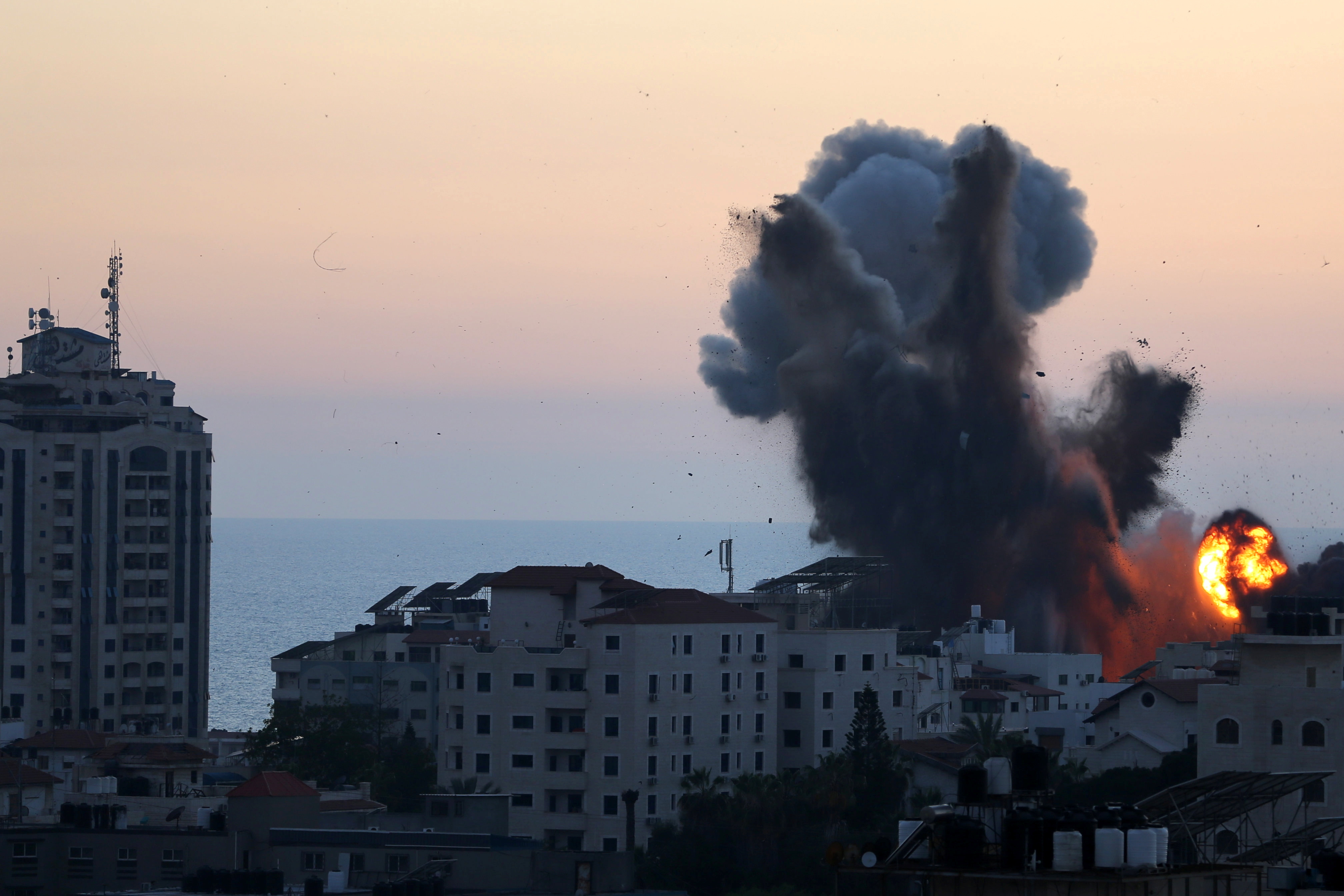 El humo y las llamas se elevan durante los ataques aéreos israelíes, mientras continúa la violencia transfronteriza entre el ejército israelí y los militantes palestinos, en la ciudad de Gaza, el 14 de mayo de 2021 (REUTERS/Ibraheem Abu Mustafa)