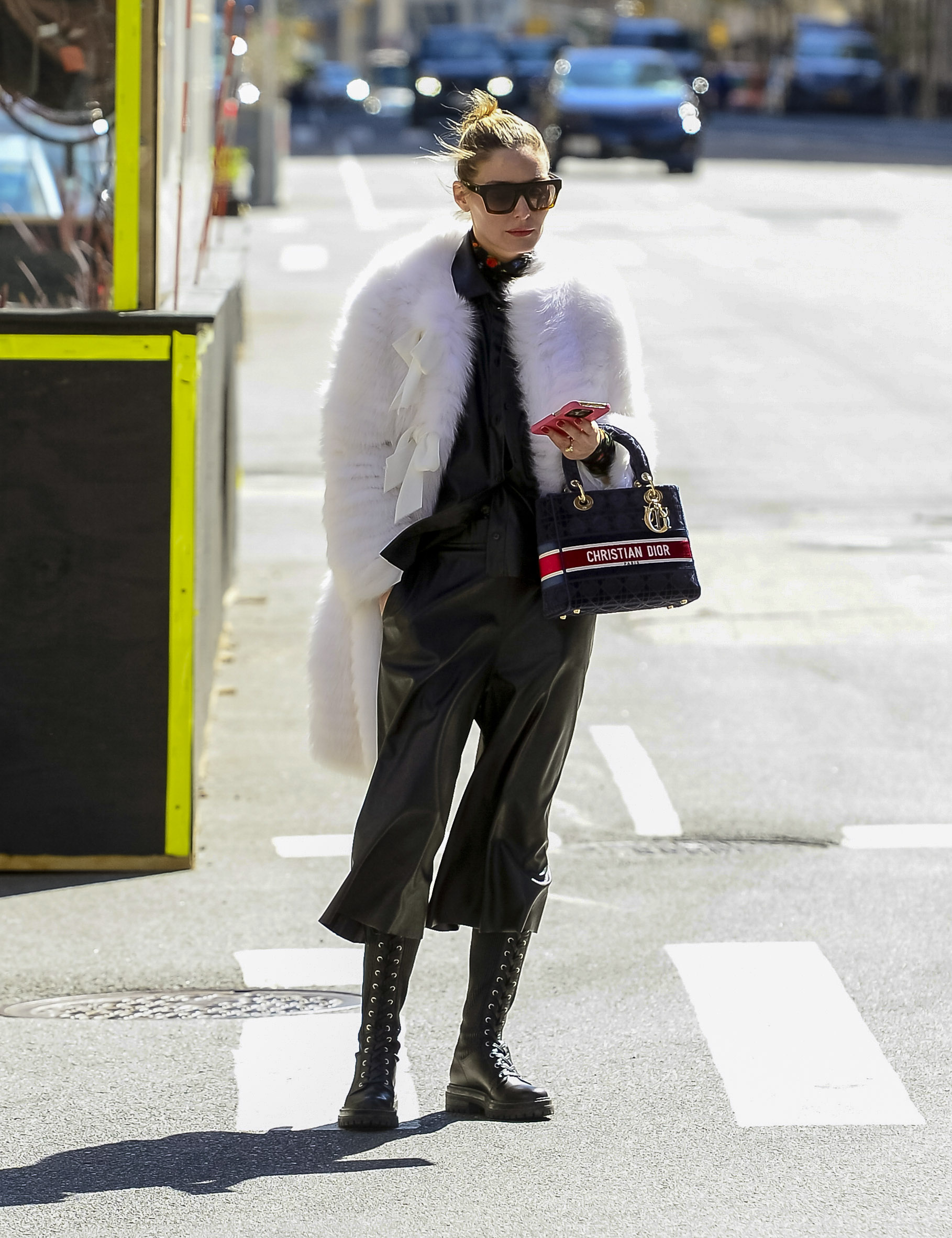 Olivia Palermo dio un paseo por las calles de Nueva York y marcó tendencia con su look: lució un pantalón negro de cuero que combinó con su camisa y sus borcegos. Y vistió un tapado blanco de piel sintética. Además, llevó una cartera Dior