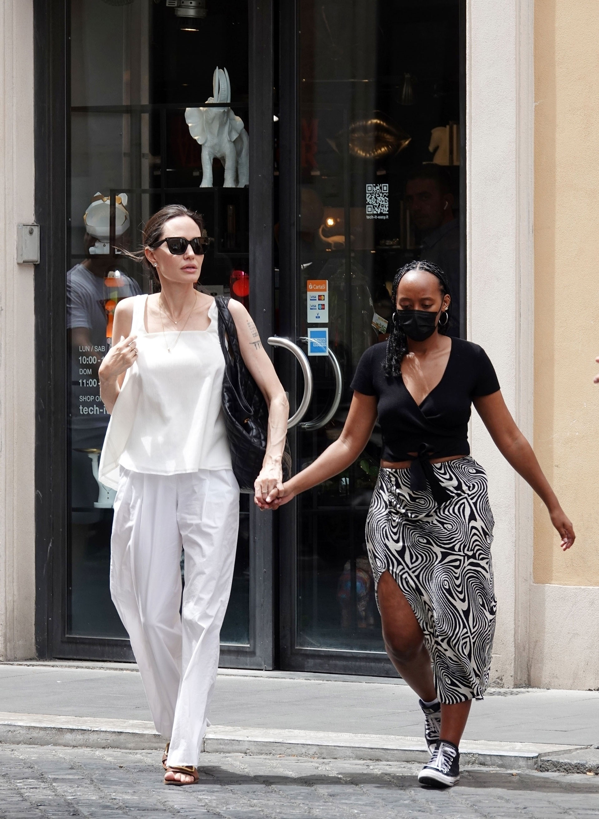 Día de compras. Angelina Jolie y su hija Zahara aprovecharon su estadía en Roma, Italia, para pasear y también recorrieron las tiendas más exclusivas de indumentaria, zapatos y accesorios. La actriz lució un look total white mientras que la adolescente optó por una pollera blanca y negra que combinó con su remera