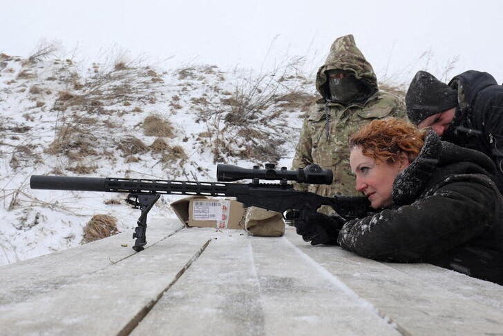 Una mujer apuntar con un arma durante una sesión de entrenamiento militar para empleados de ciudades industriales de Ucrania en las afueras de Lviv. Enero 25, 2022. REUTERS/Roman Baluk