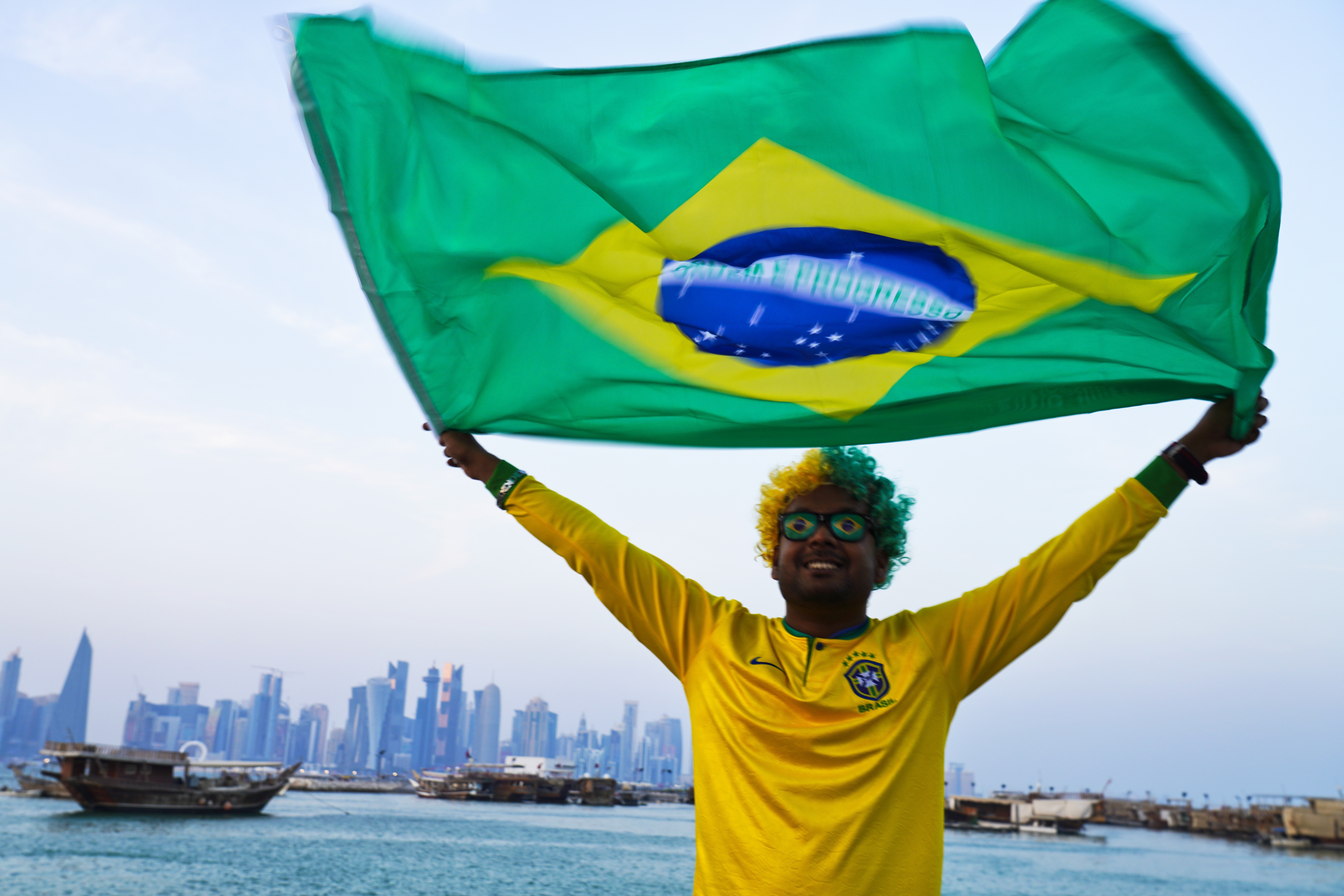 Un hincha de Brasil agita la bandera brasileña en Doha, Qatar, el viernes 18 de noviembre de 2022.  (AP Foto/Jon Gambrell)