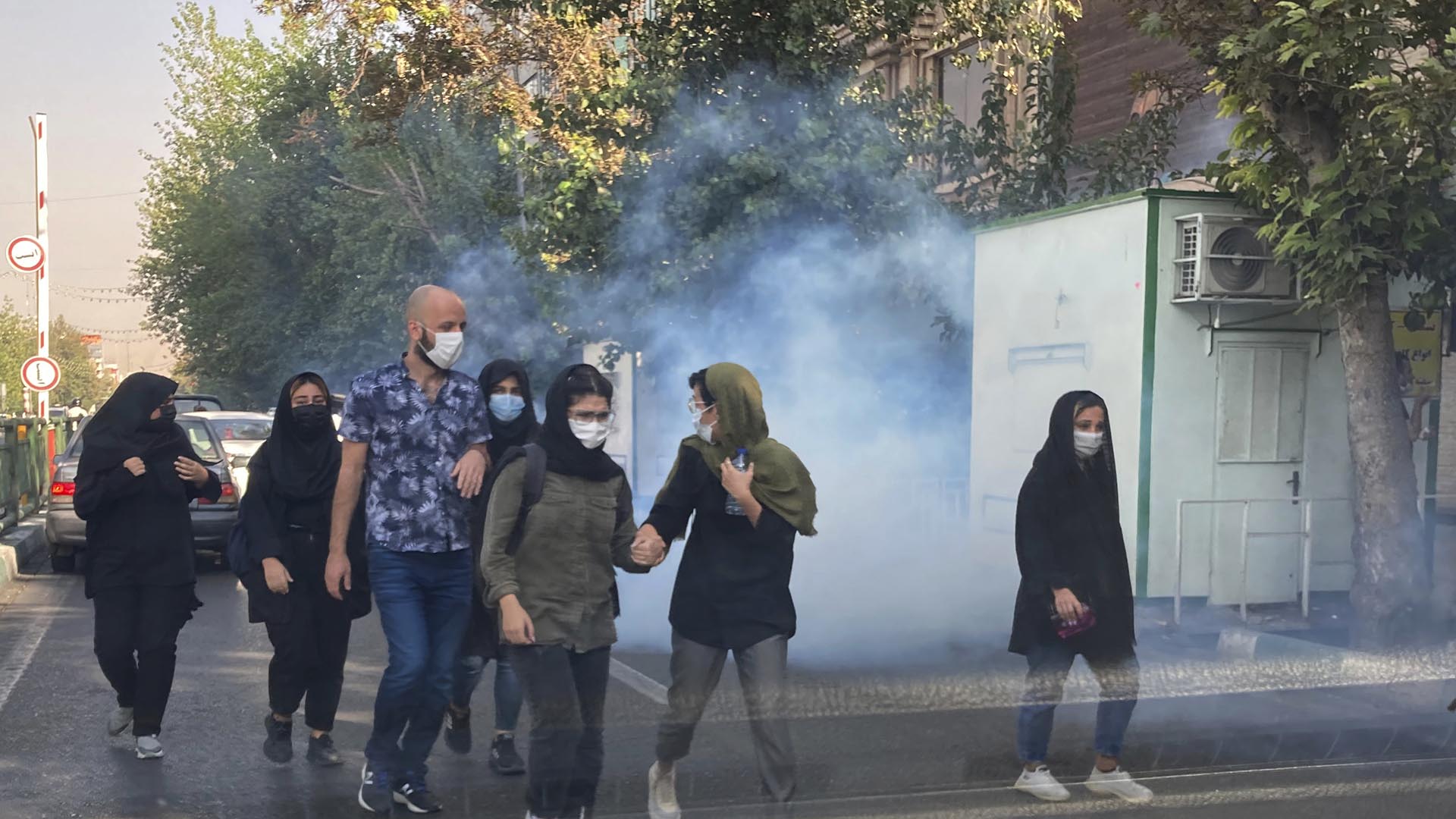 ARCHIVO - En esta foto del sábado 1 de octubre de 2022, tomada por un individuo no empleado por Associated Press y obtenida por la AP fuera de Irán, la seguridad dispara gas lacrimógeno para dispersar a los manifestantes frente a la Universidad de Teherán, Irán. (AP Photo, File)