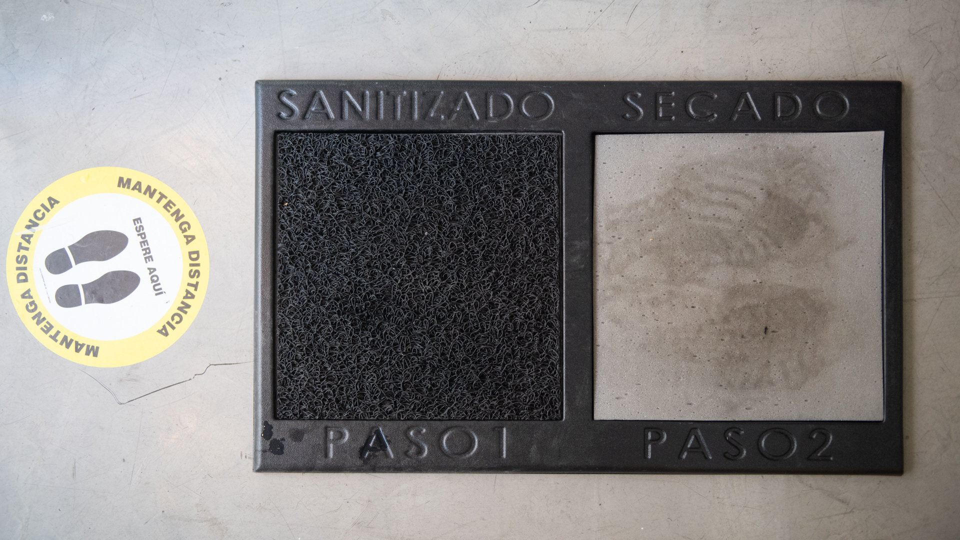 Señaletica para mantener distancia social y alfombra sanitizante