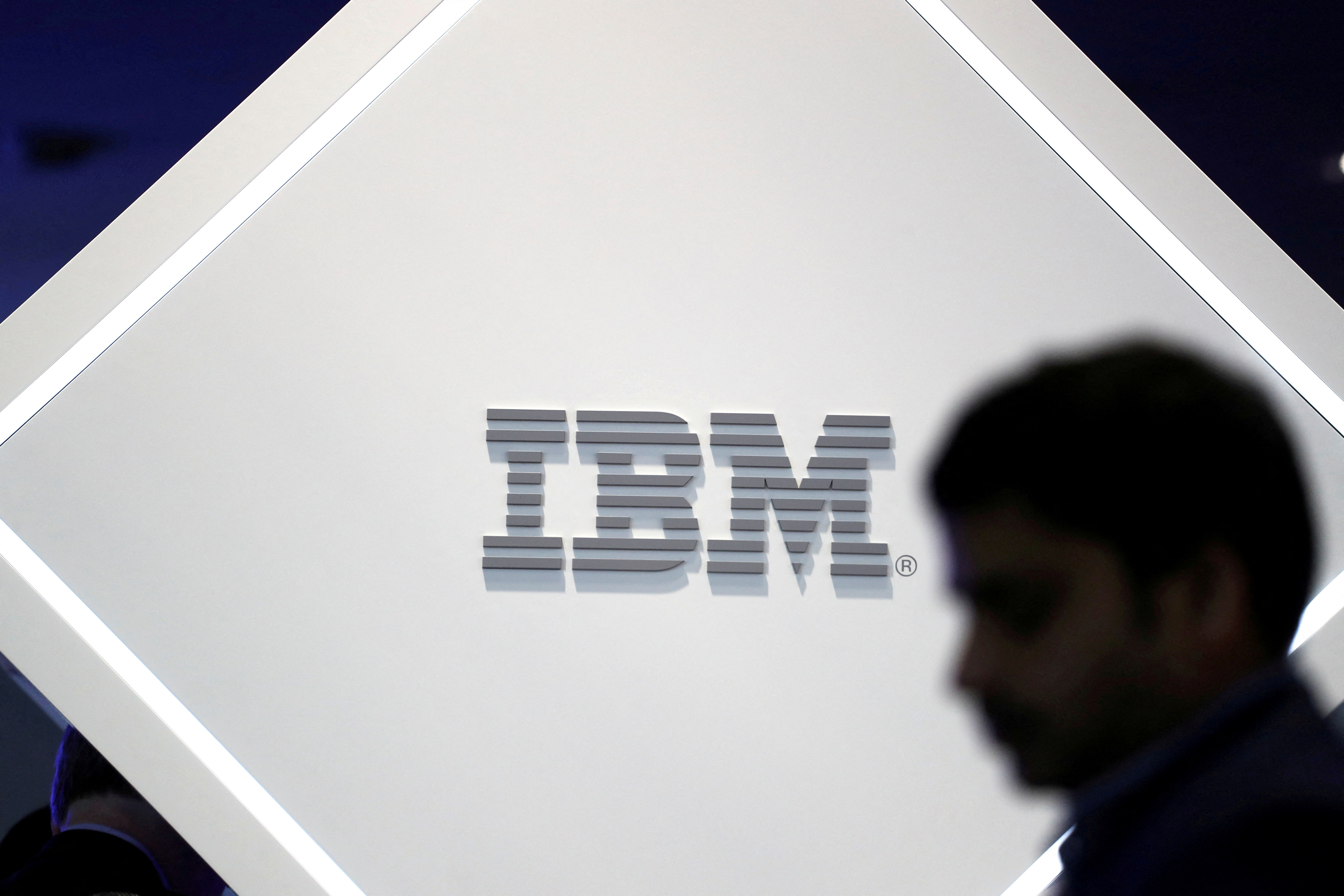 FILE PHOTO: A man stands near an IBM logo at the Mobile World Congress in Barcelona, ​​Spain, February 25, 2019. REUTERS/Sergio Perez//File Photo